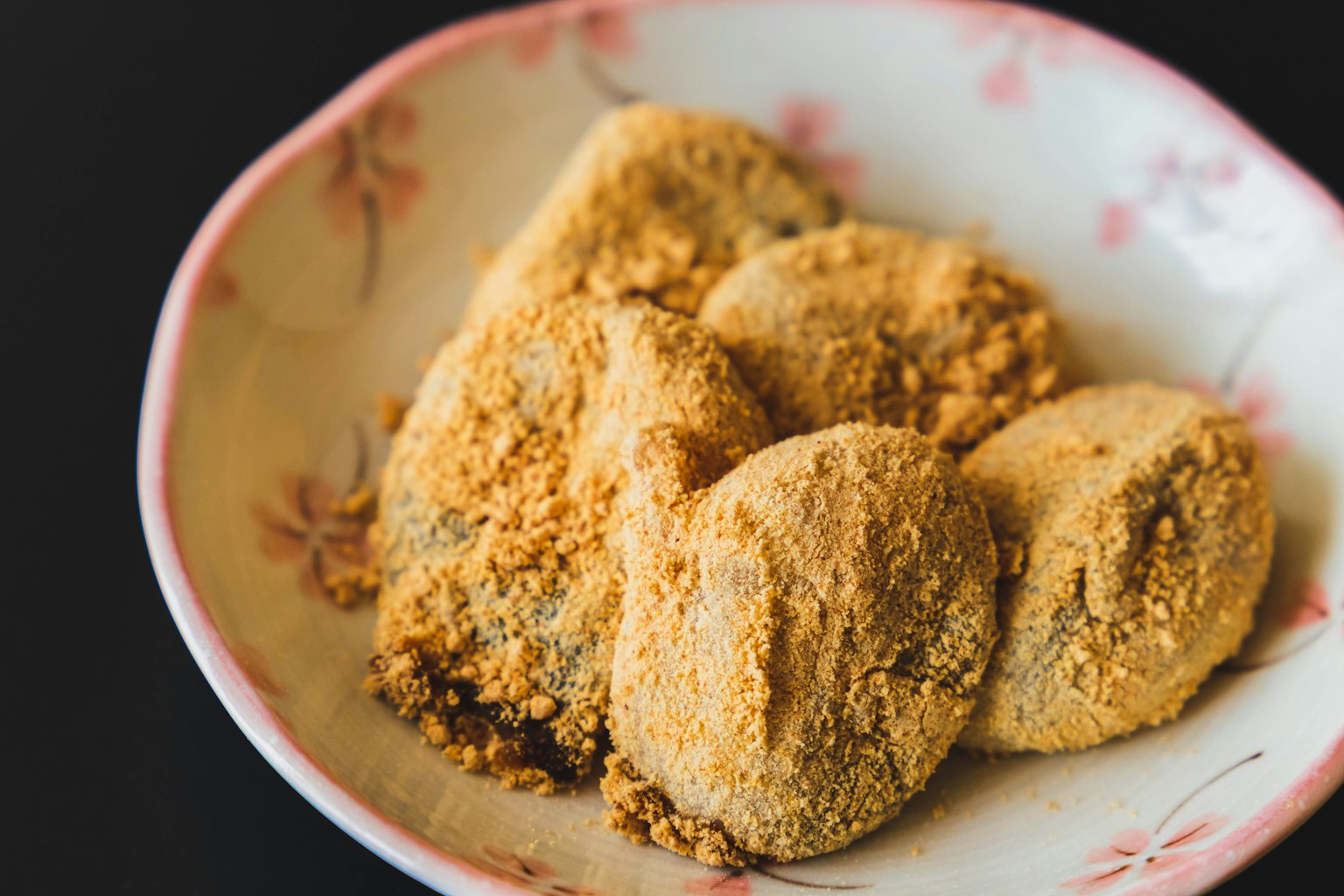 Dolcetti rotondi coperti di polvere marrone serviti su un piatto decorativo
