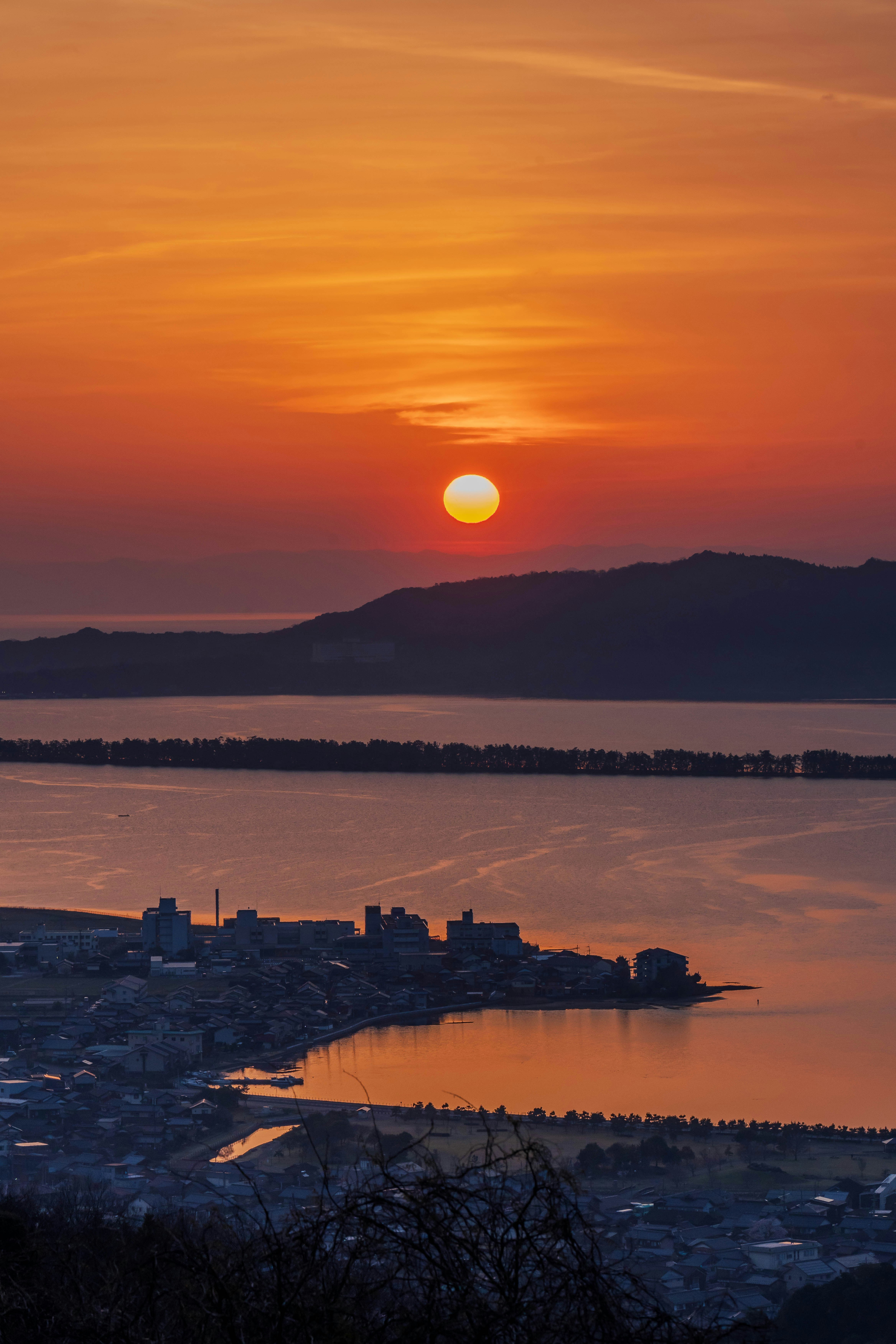 日の出の空と湖に映る夕明かりの風景