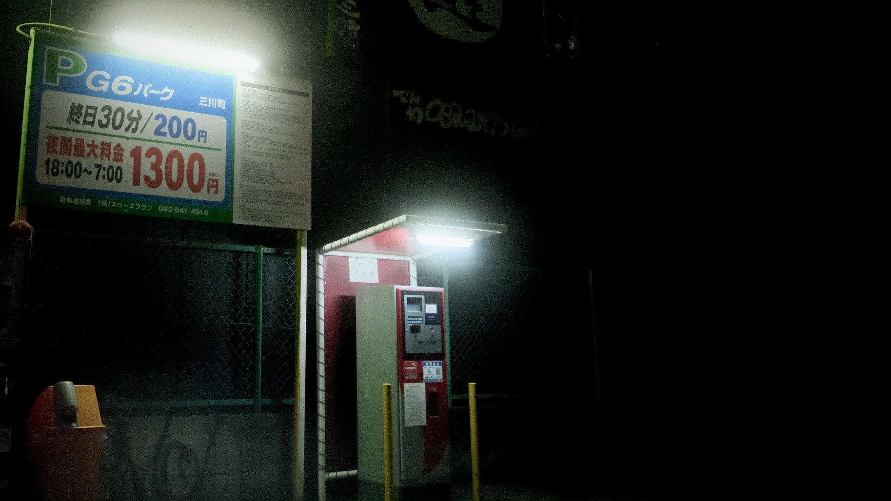 night street corner with vending machine and illuminated signage