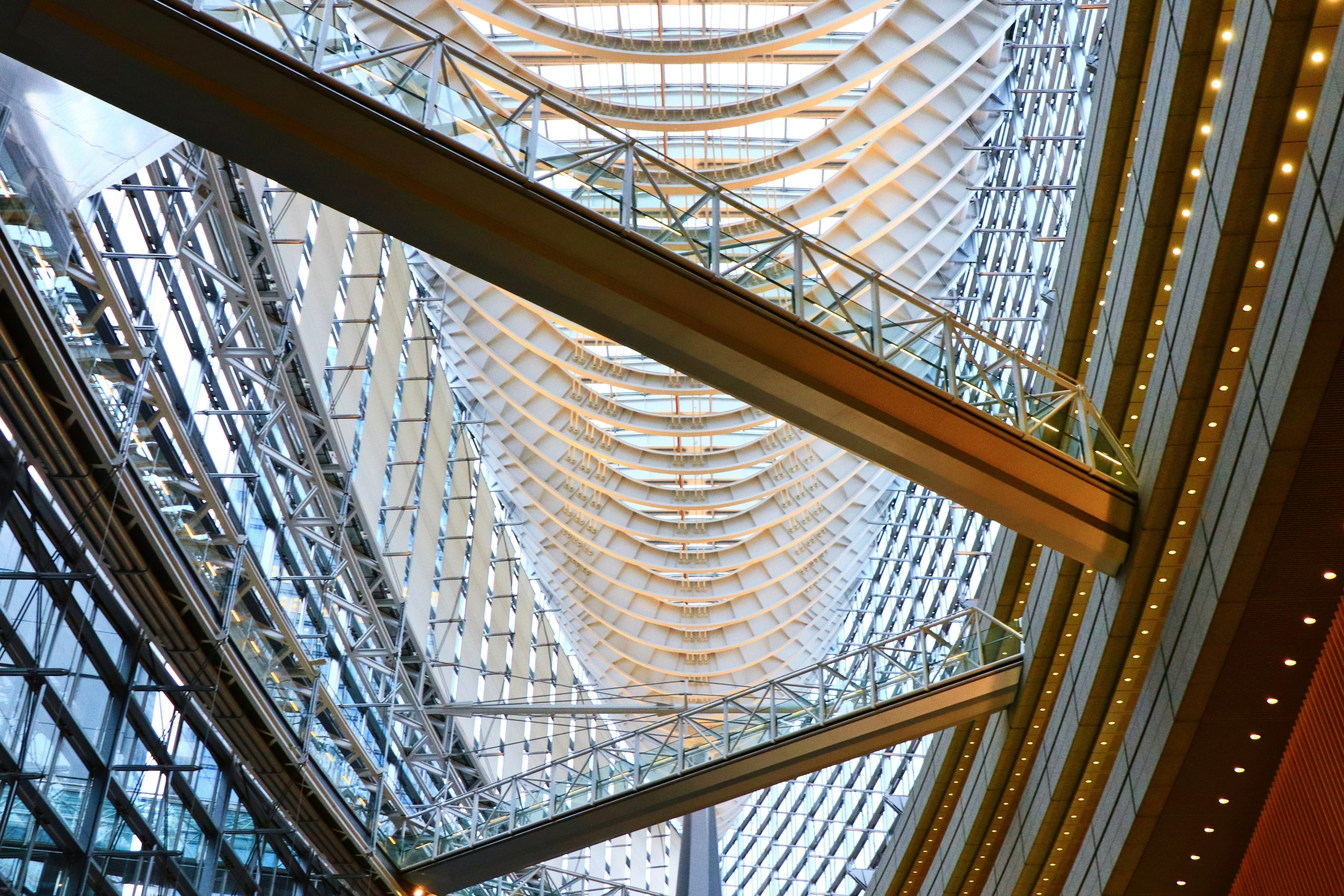 glass-roofed atrium ceiling with intersecting metal framework