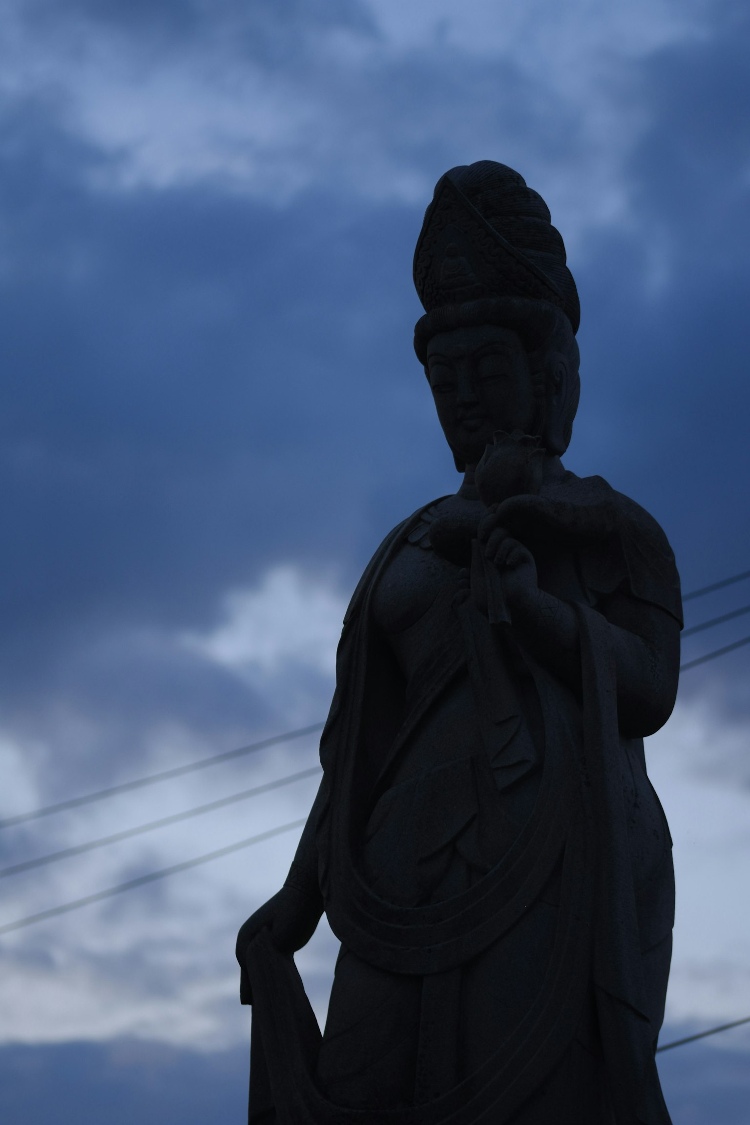 Silueta de una estatua oscura contra un cielo nublado