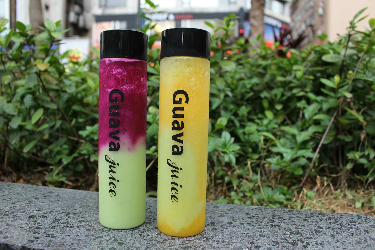 Dua botol jus guava berwarna hijau dan kuning