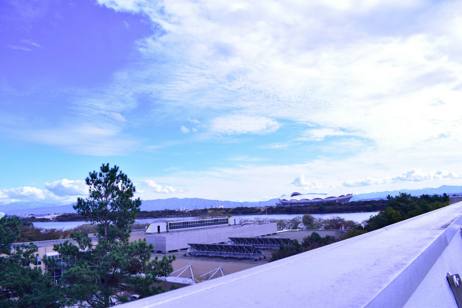 Pemandangan langit biru dengan awan dan bangunan di latar depan