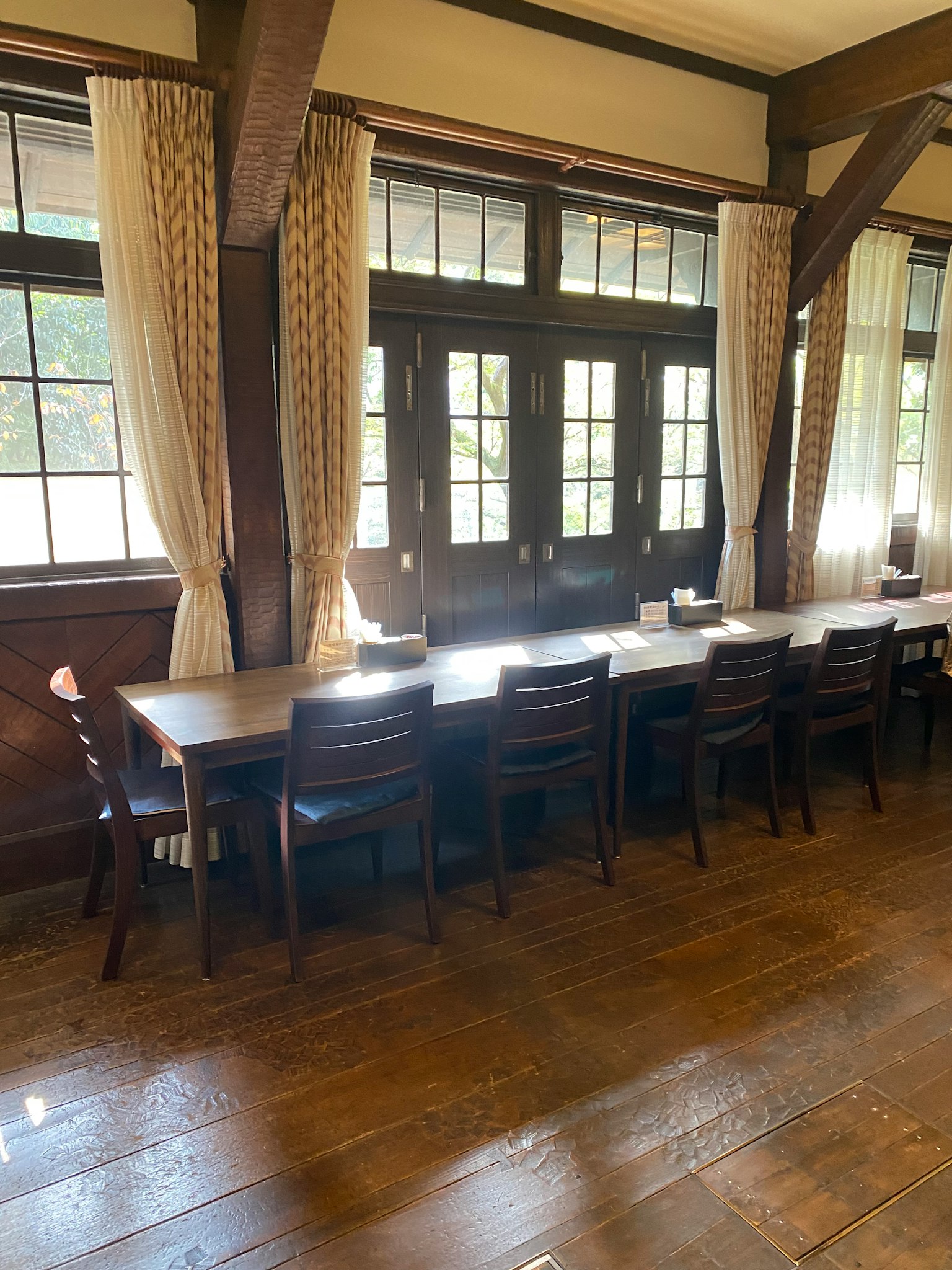 Bright room with wooden table and chairs natural light streaming through windows
