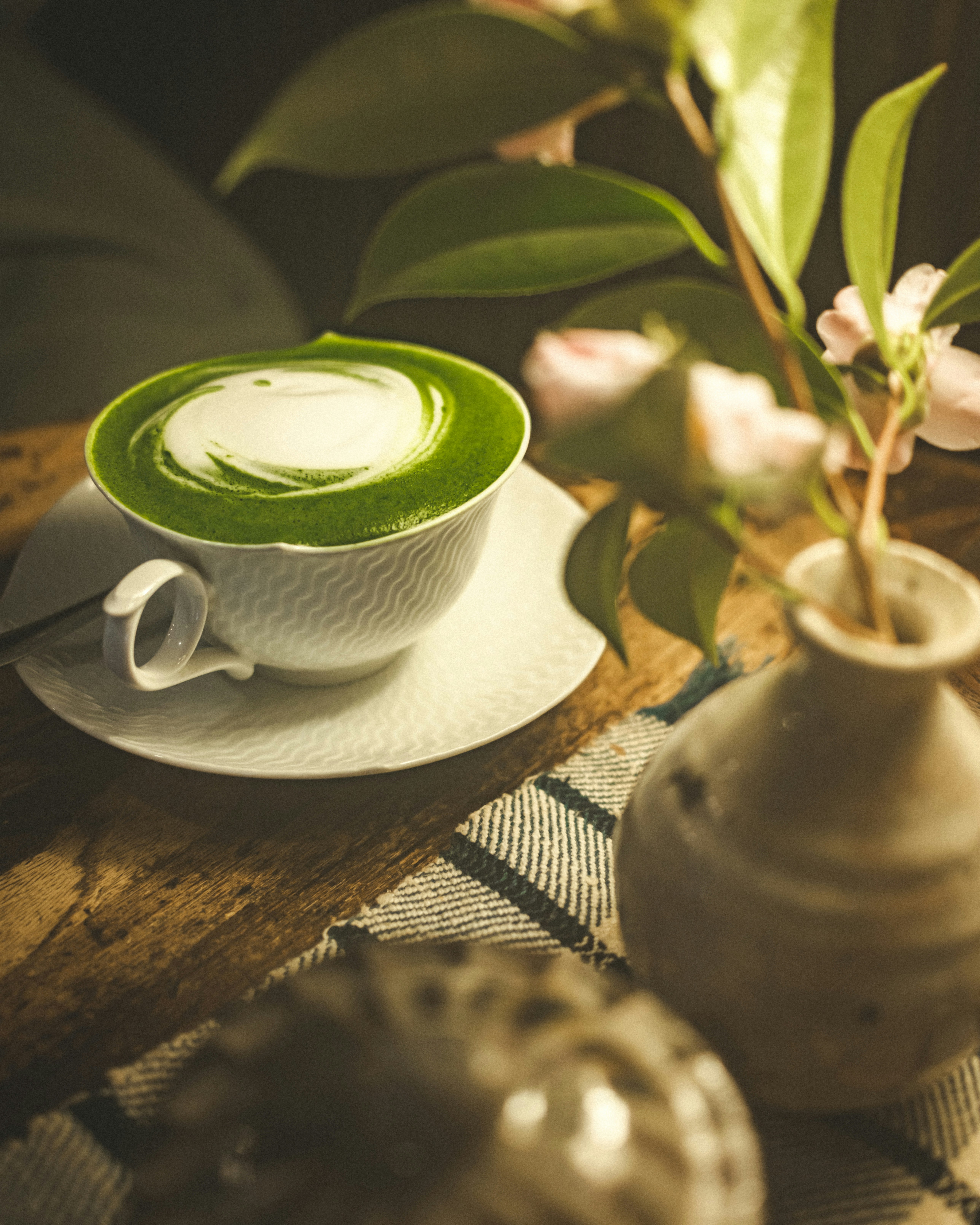 抹茶ラテの泡と茶碗のある和風喫茶のテーブル