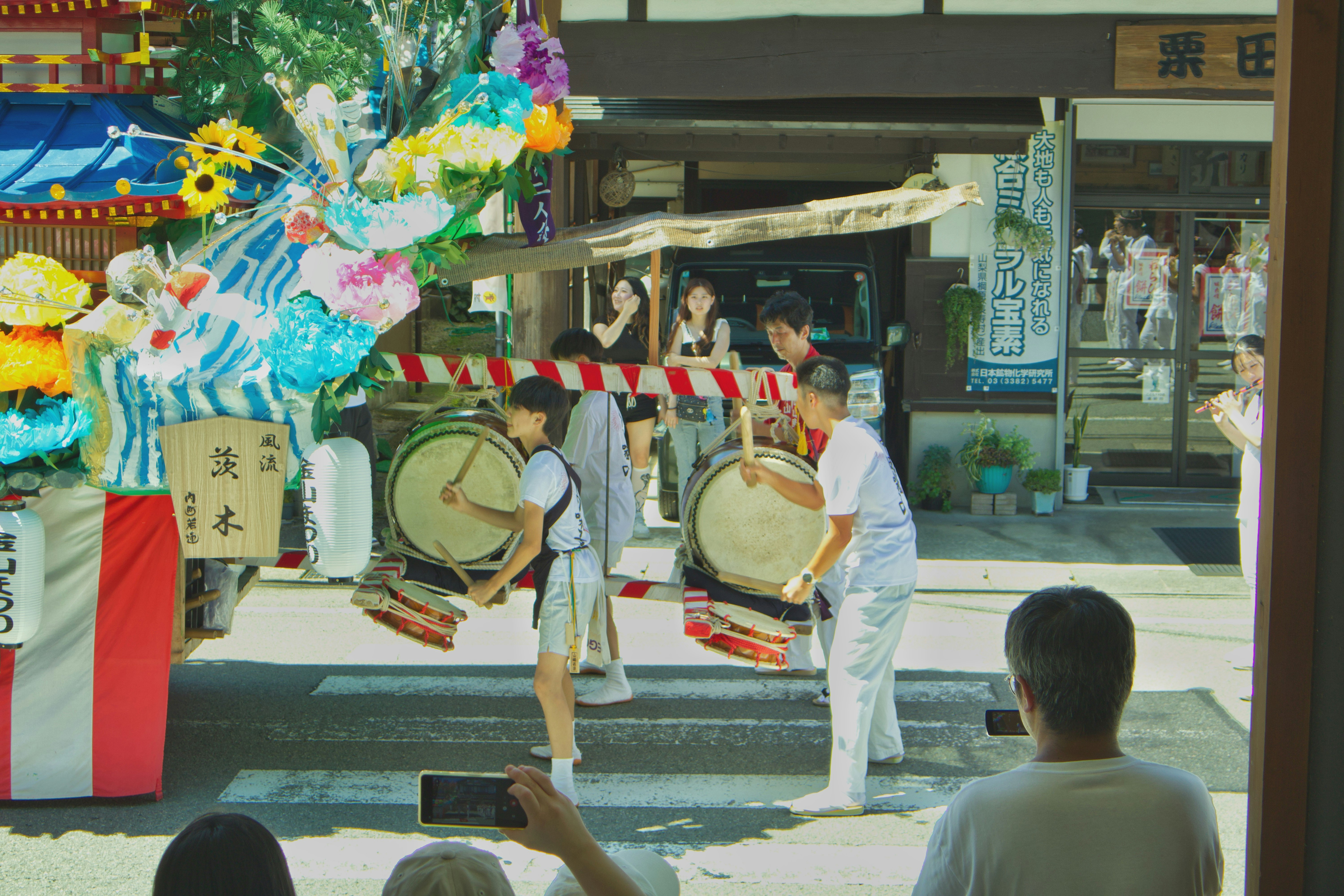 和太鼓の演奏と観客が見守る屋外イベントの舞台
