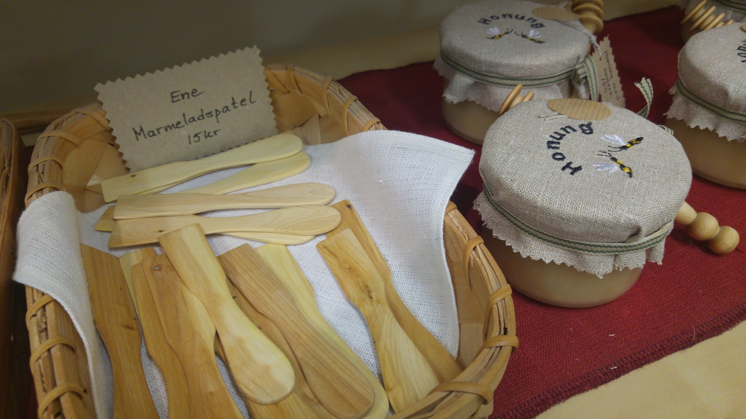 Cestino con cucchiai di legno e barattoli di marmellata