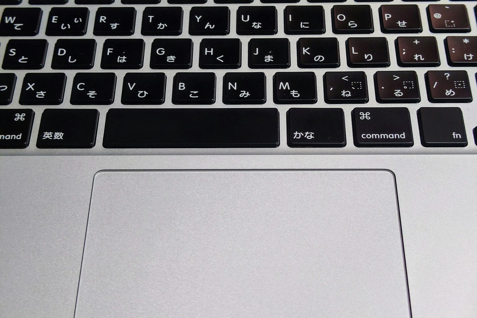 Close-up of a laptop keyboard featuring black keys and a silver palm rest