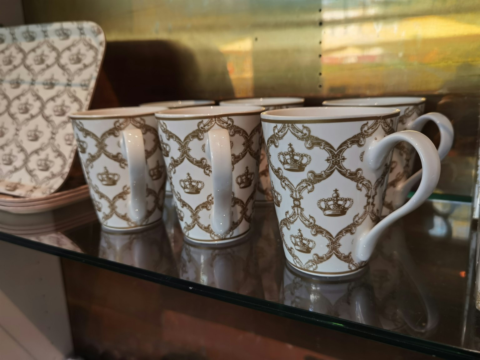 Tazas de porcelana blanca decoradas con patrones de coronas doradas