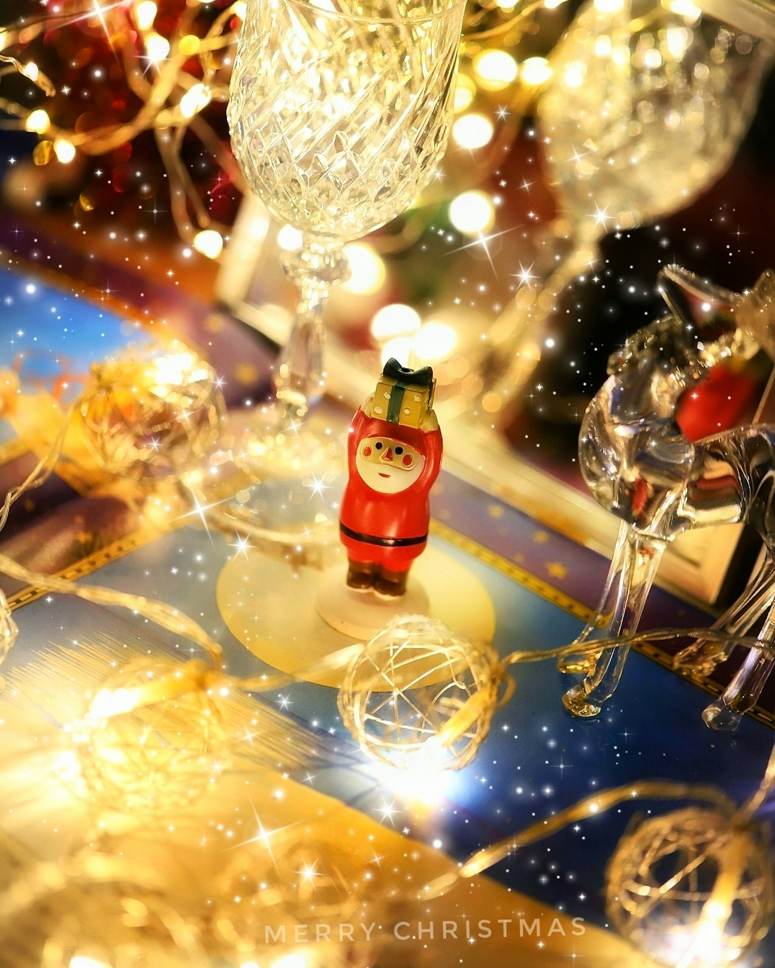 Pequeña figurita de Santa rodeada de decoraciones navideñas y luces