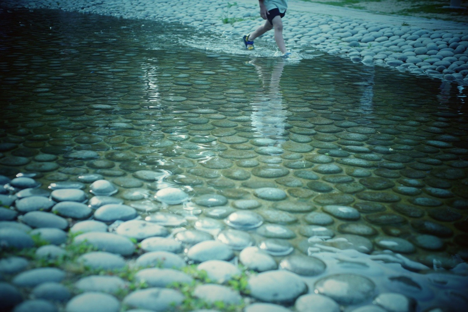 shallow river with smooth round pebbles and rippling water