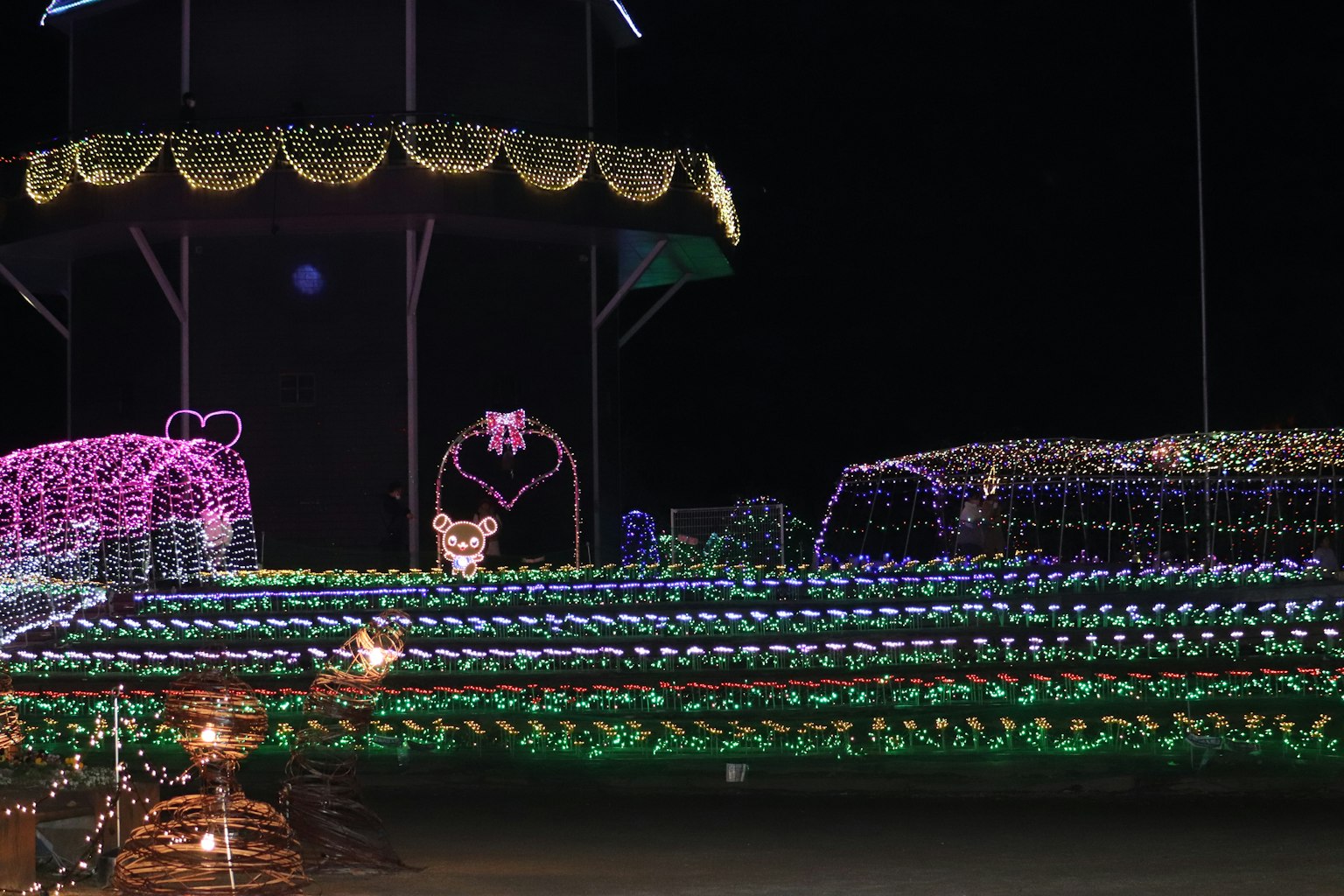 Scena notturna adornata con decorazioni luminose colorate che presentano vari display illuminati