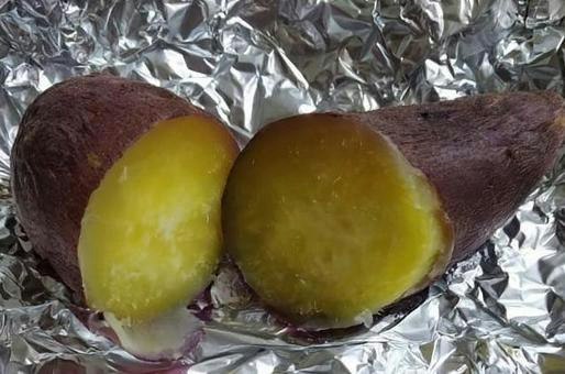 cross-section of roasted sweet potatoes on aluminum foil