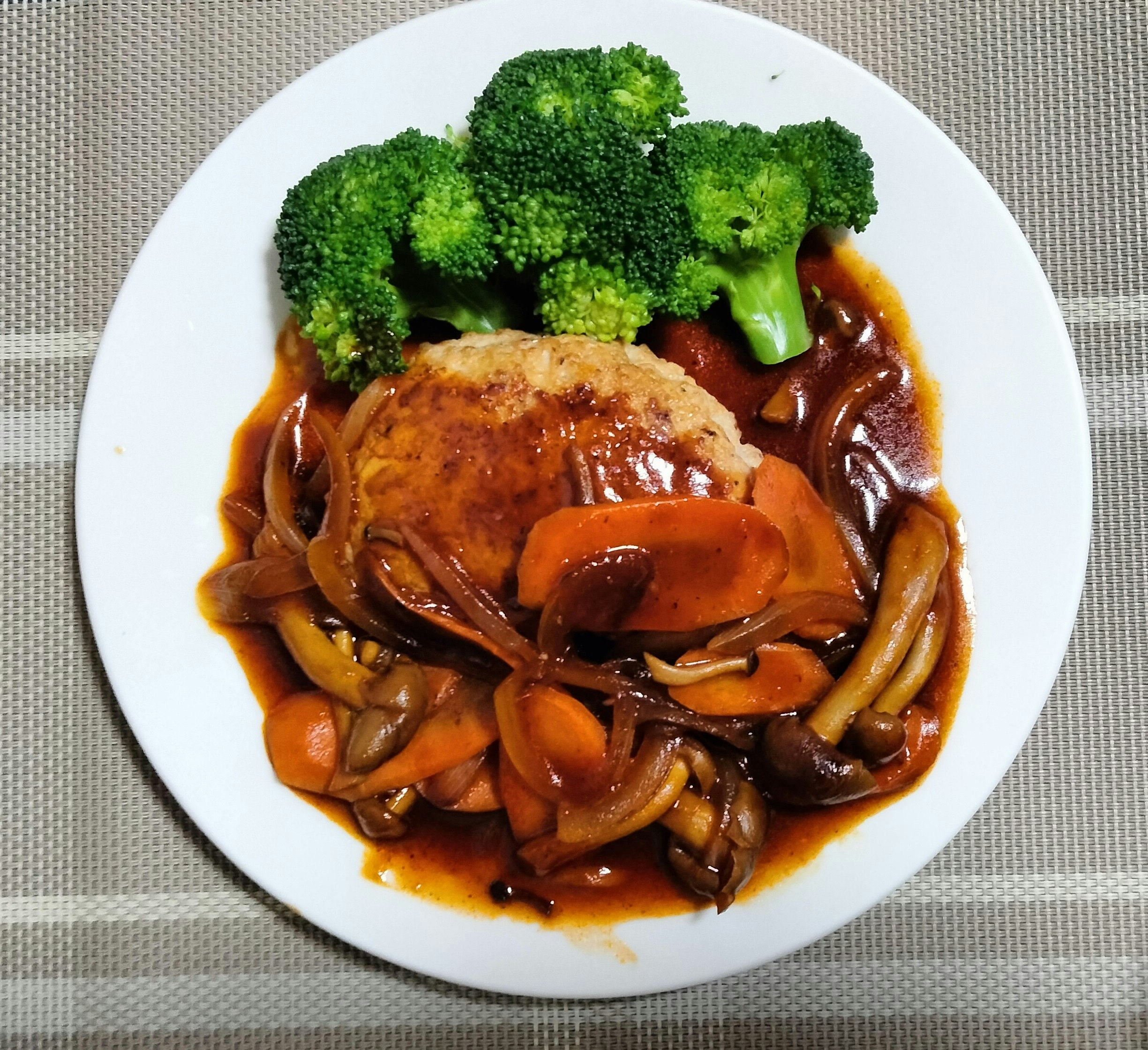 Hamburger-style dish on a plate with rich sauce