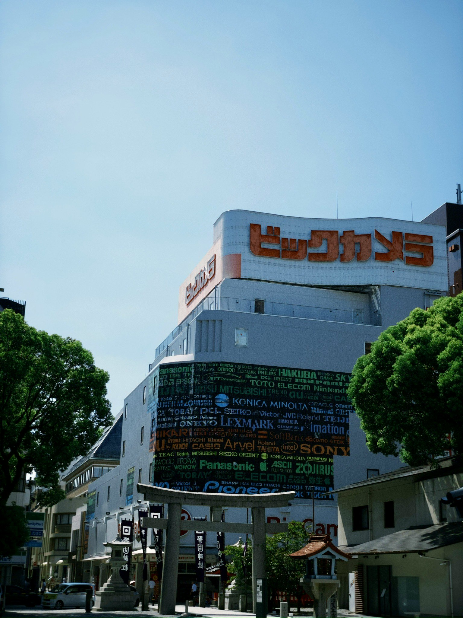 青空の下にそびえる大型ビルの外壁看板