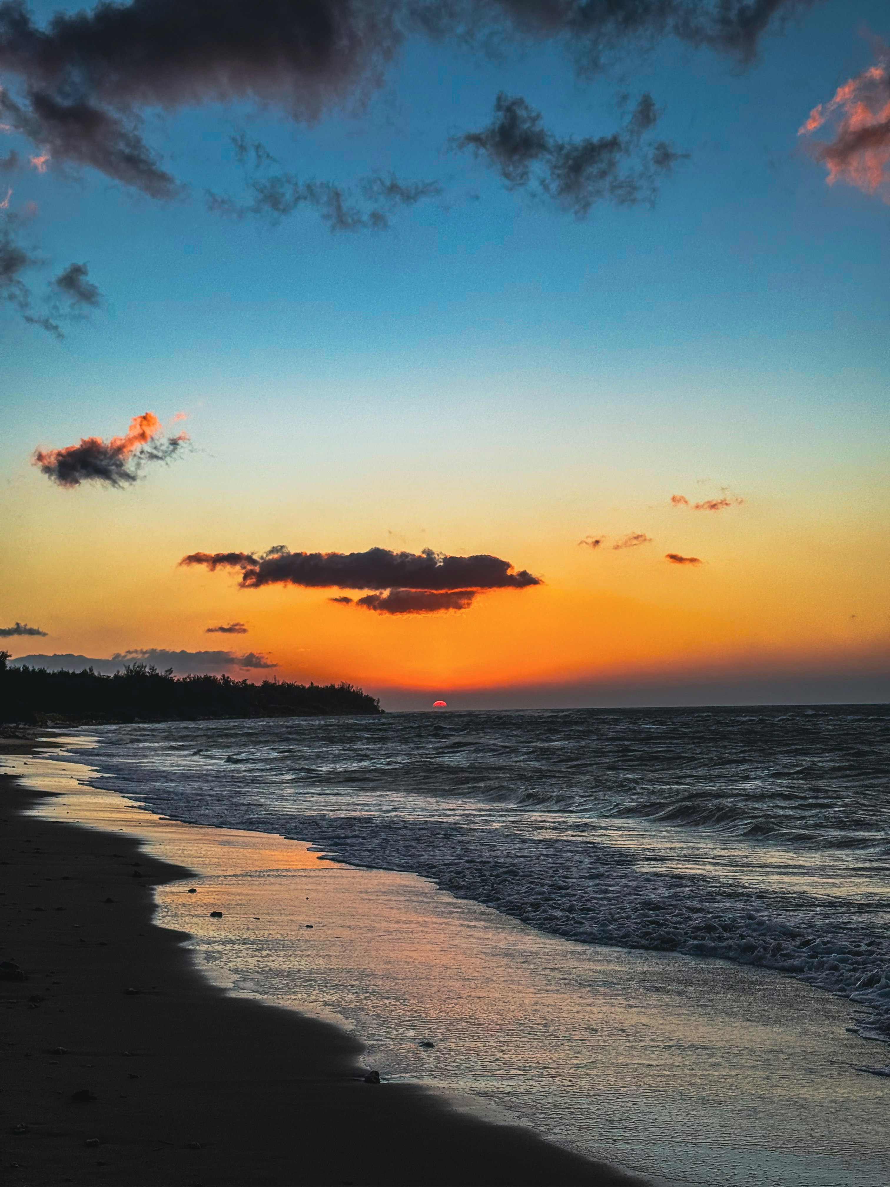 水平線に広がる海辺の夕焼け空と波のきらめき