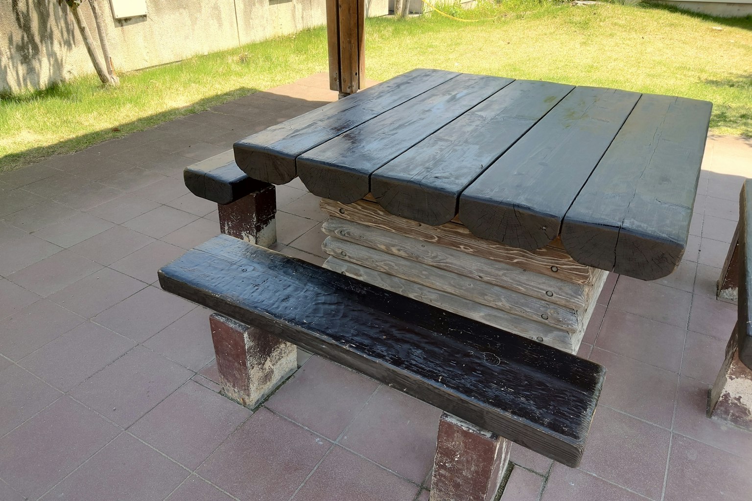 Area di sosta all'aperto con tavolo e panchina in legno