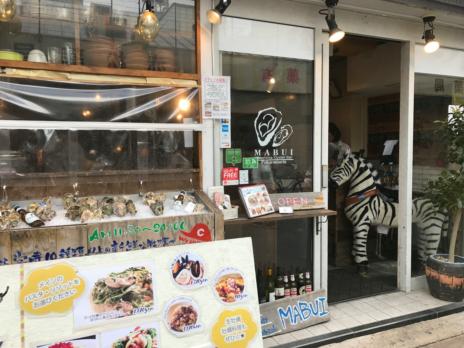 Entrance of a restaurant featuring a menu board and a zebra decoration