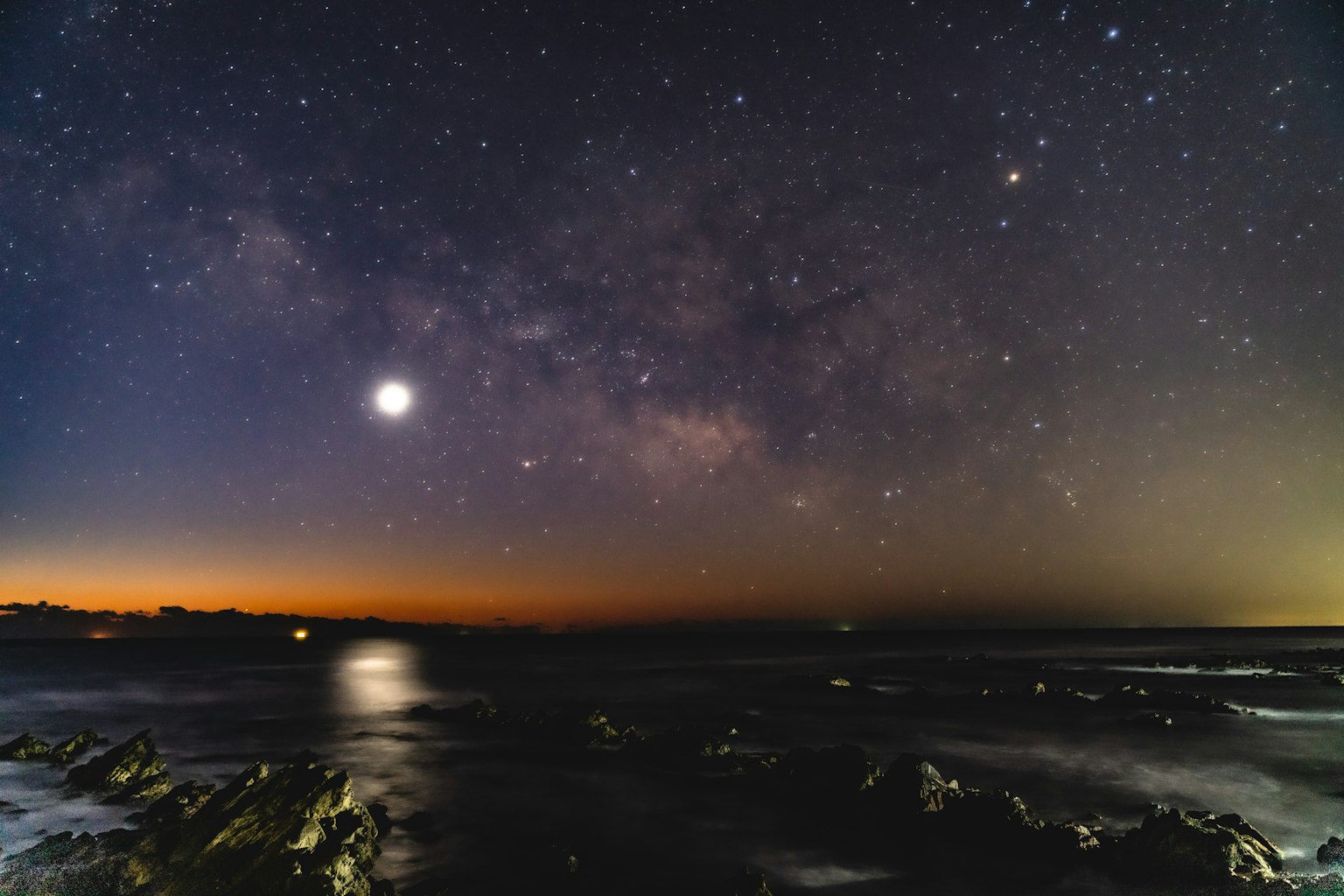 壯觀的夜空，滿月和銀河在海洋上方