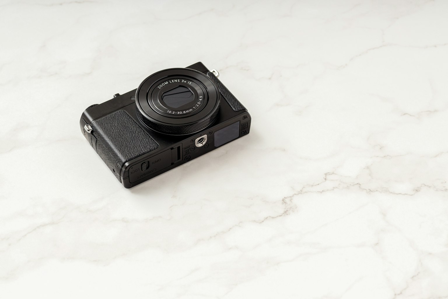 Schwarze Kamera auf einer weißen Marmoroberfläche platziert