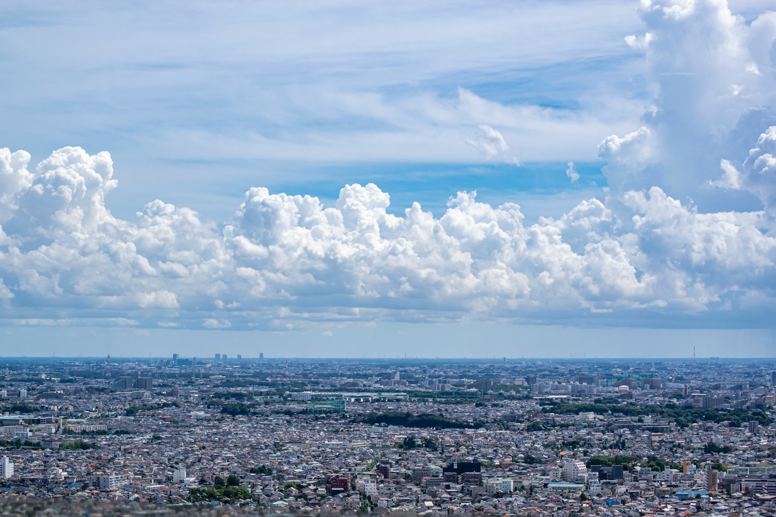 ทิวทัศน์แบบพาโนรามาของเมืองที่มีเมฆขาวและท้องฟ้าสีฟ้า