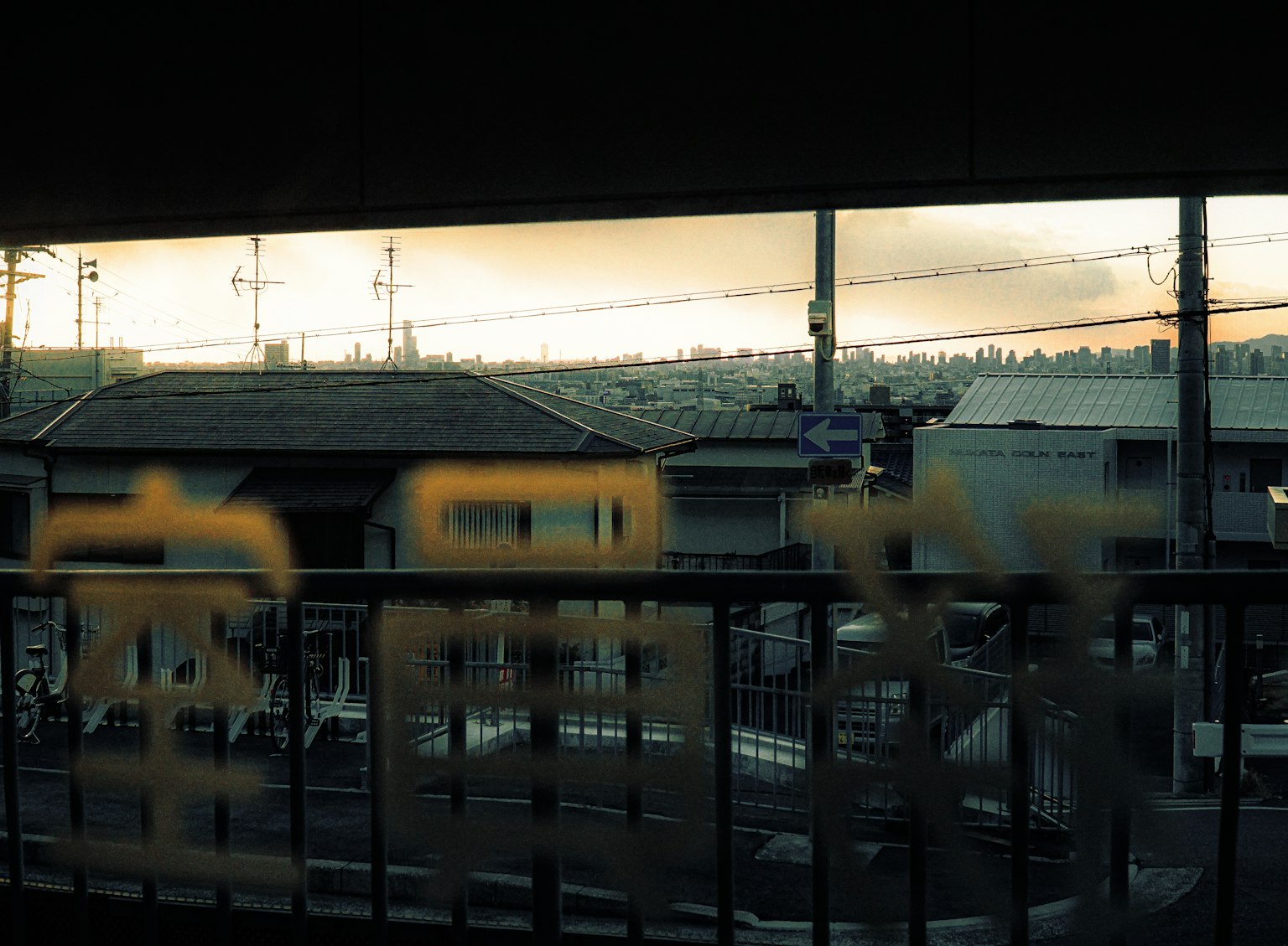 Vista dalla finestra con tramonto e caratteri giapponesi in primo piano