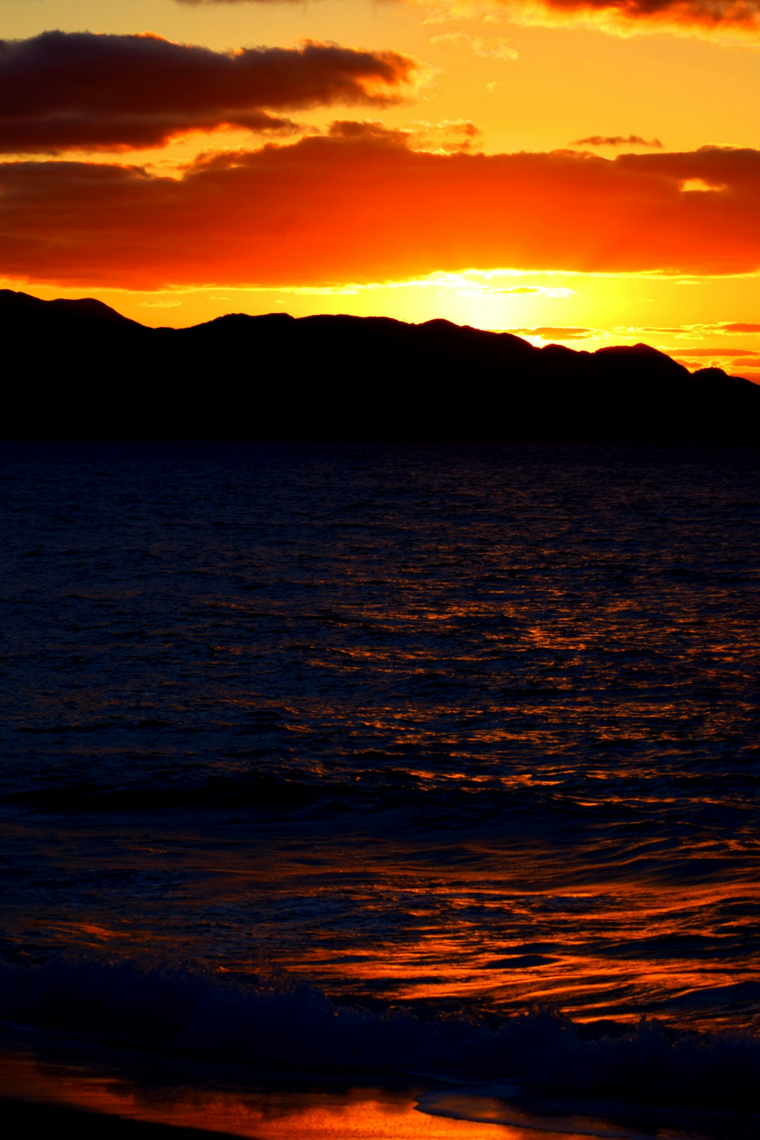 Beeindruckende Landschaft mit Sonnenuntergang, der sich im Ozean spiegelt