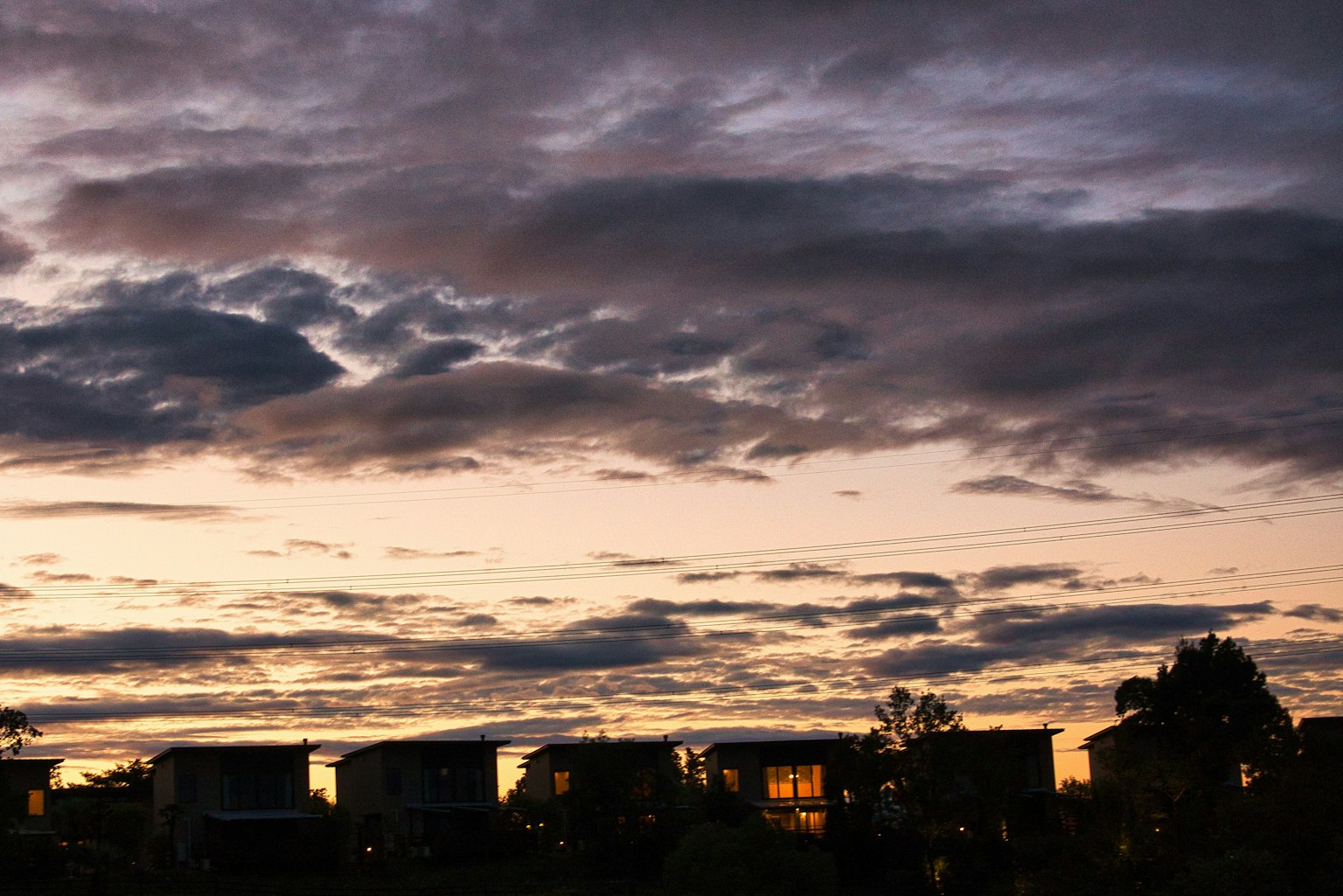 Bâtiments en silhouette contre un ciel de coucher de soleil avec des nuages