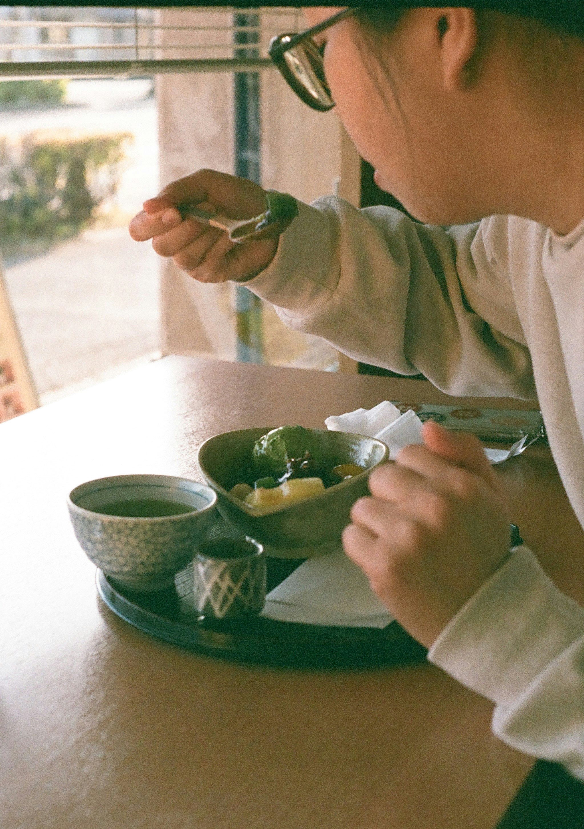 窓辺で緑の抹茶を点てる手元のカフェ時間
