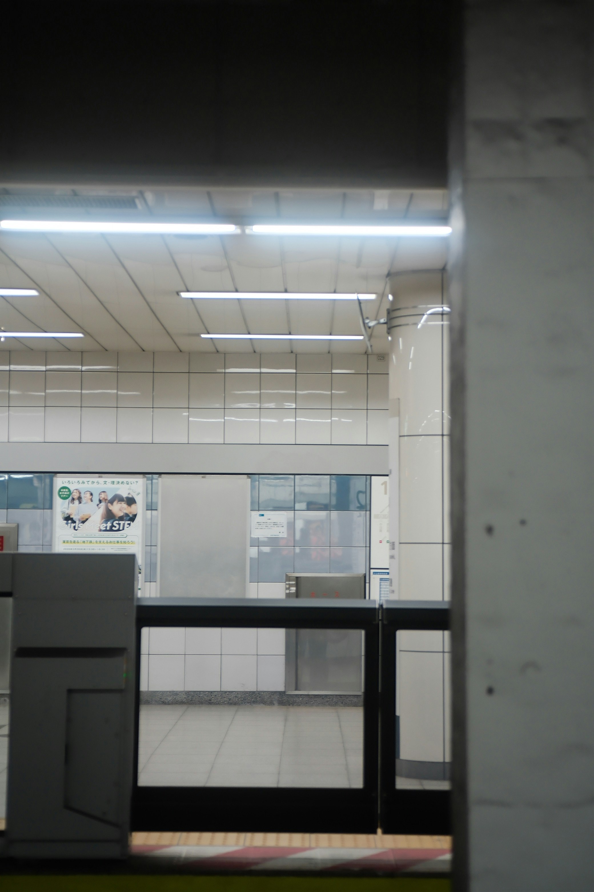 地下鉄の駅の待合室の内部の写真 照明が明るくタイルの壁が特徴