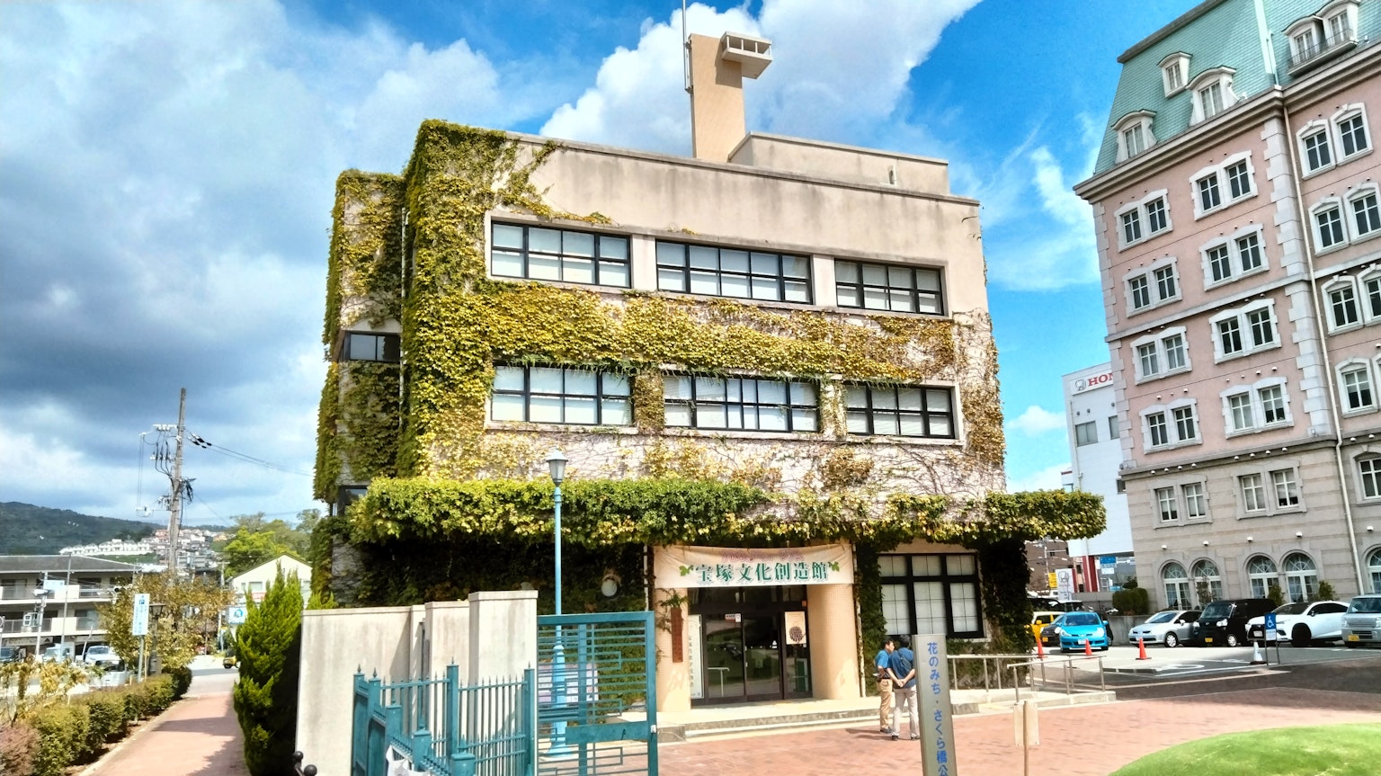 Edificio cubierto de vides verdes contra un cielo azul