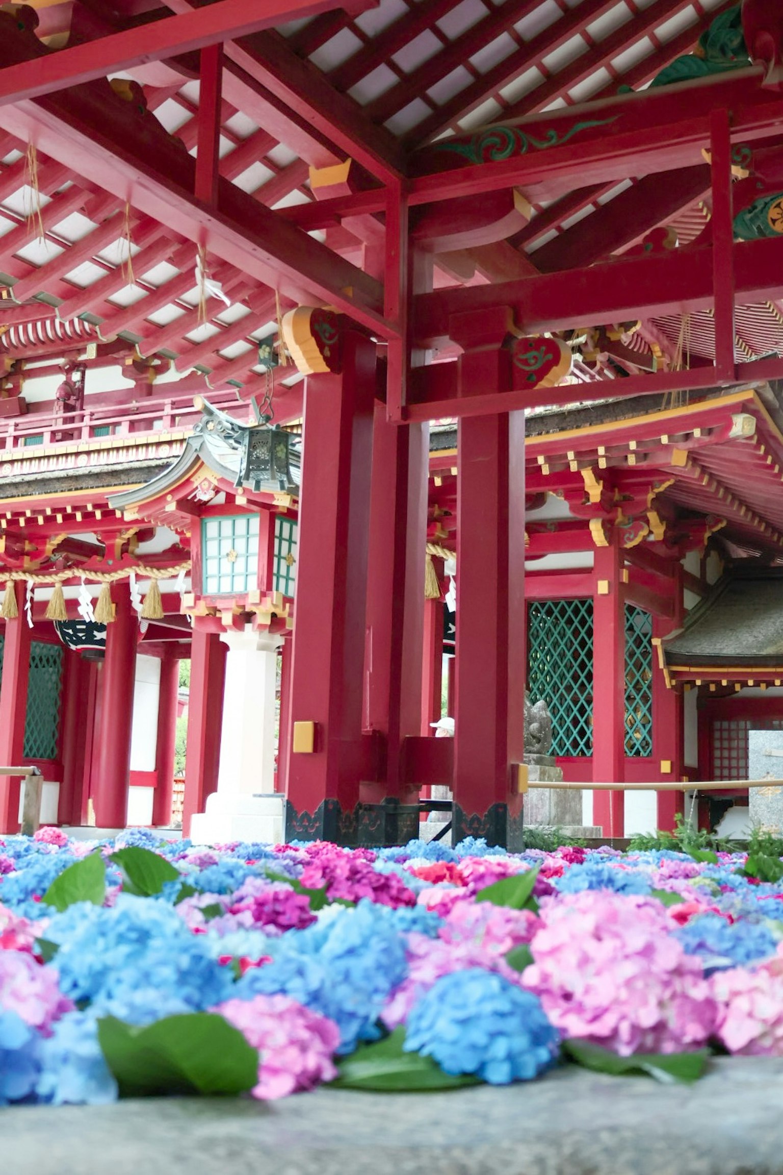 Cour intérieure traditionnelle avec des piliers rouges et des fleurs colorées