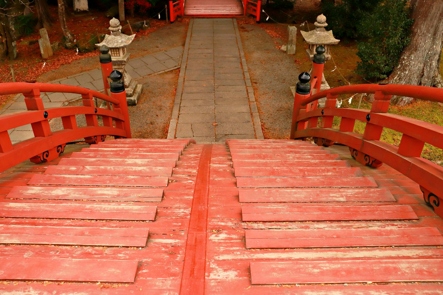 Vista di un ponte rosso che porta a un sentiero in un giardino giapponese