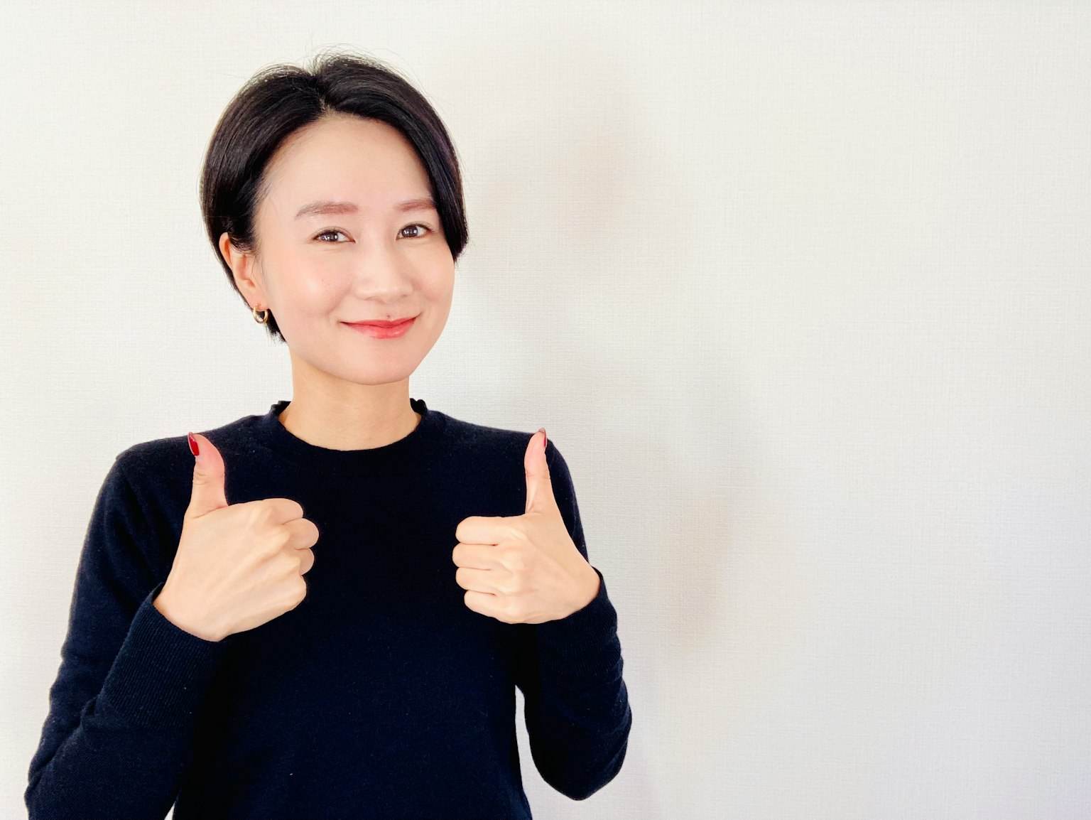 一位女性微笑并竖起大拇指的简单肖像