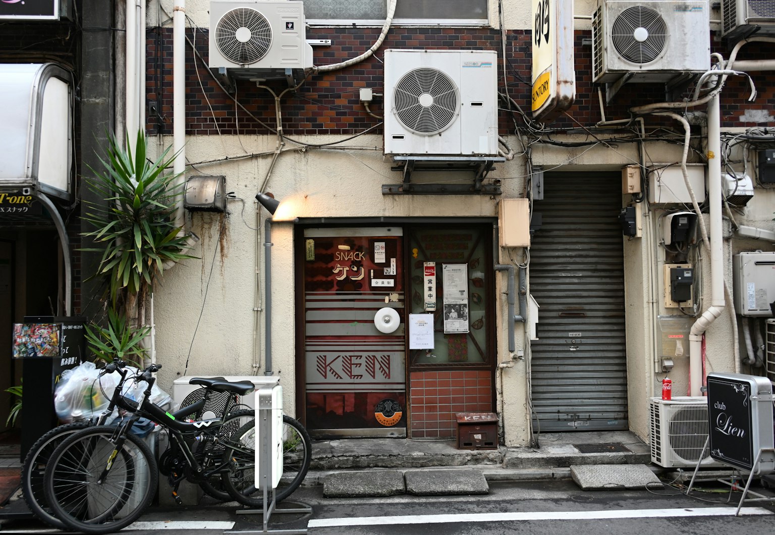 Facade of an old building with multiple air conditioning units bicycles parked at the entrance