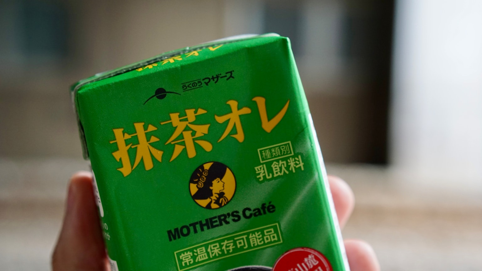 Emballage de latte au matcha vert tenu dans une main