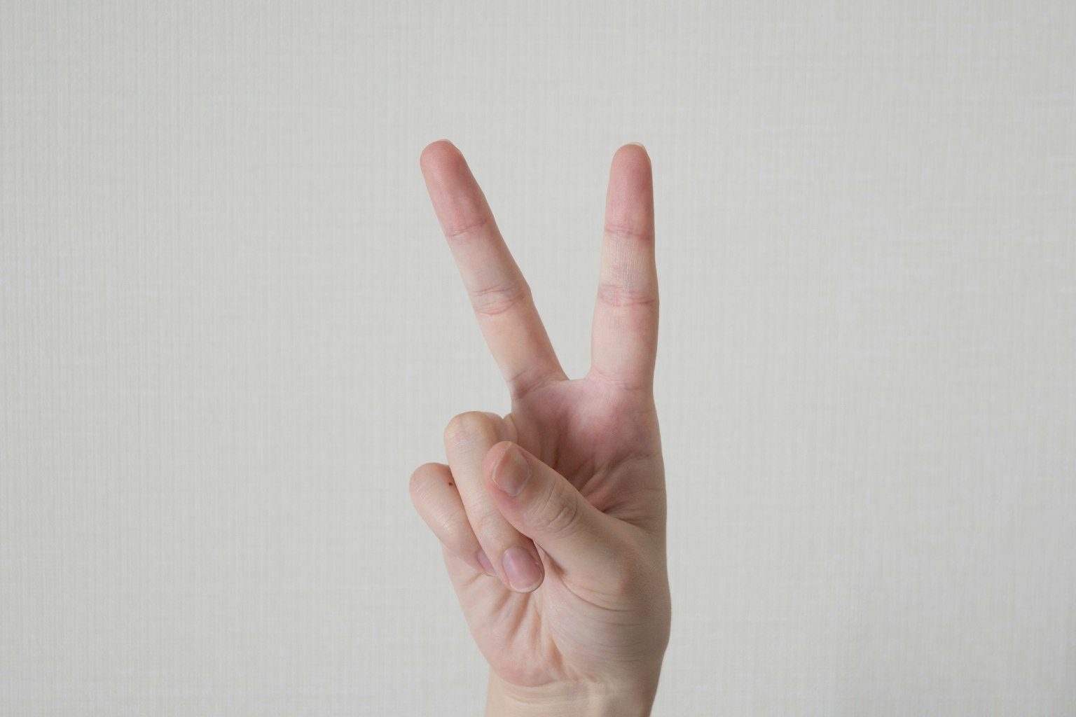 手展示V字手勢，手指抬起