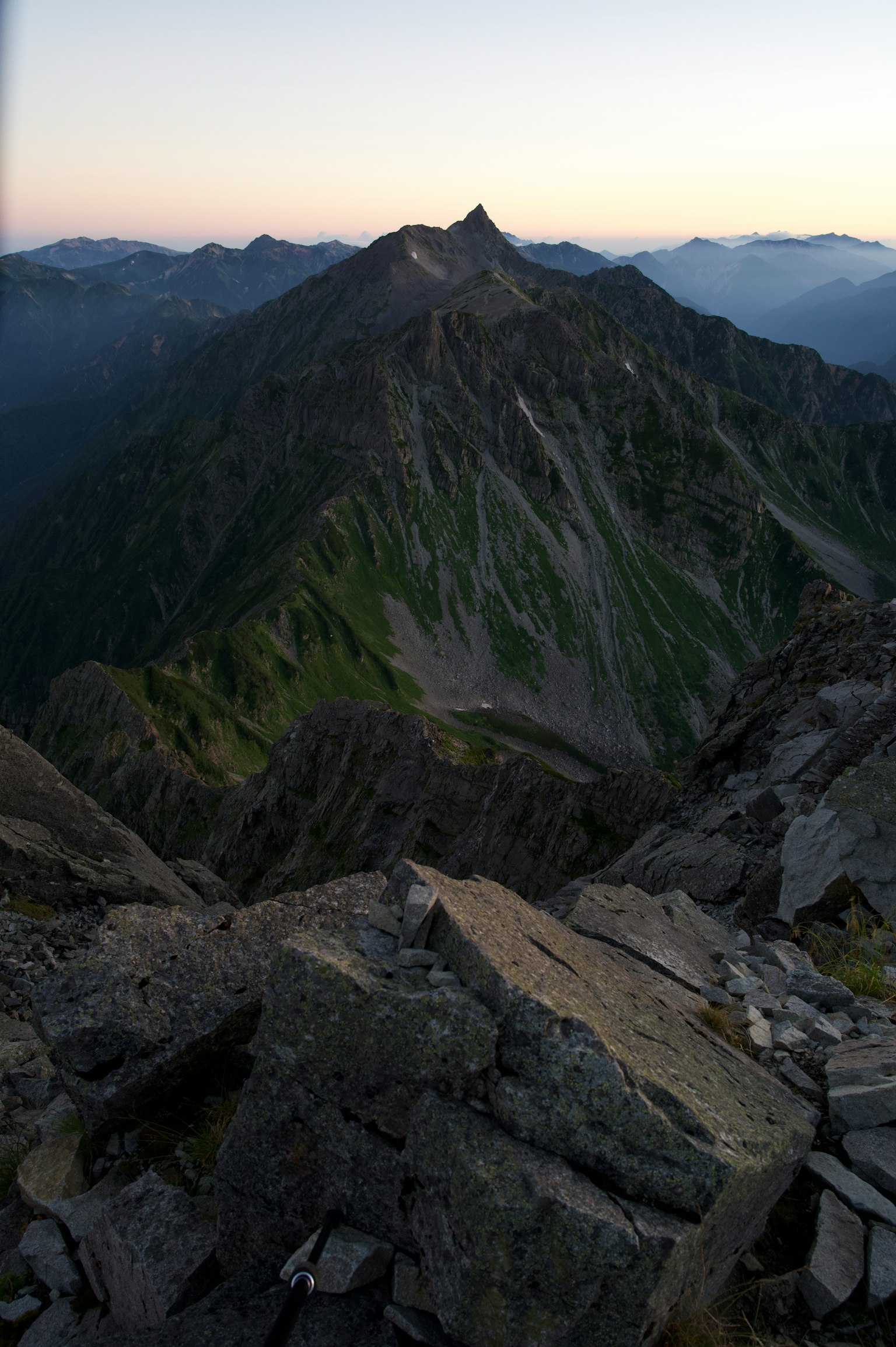 Panoramablick von einem Berggipfel felsiges Gelände sanftes Abendlicht entfernte Gipfel