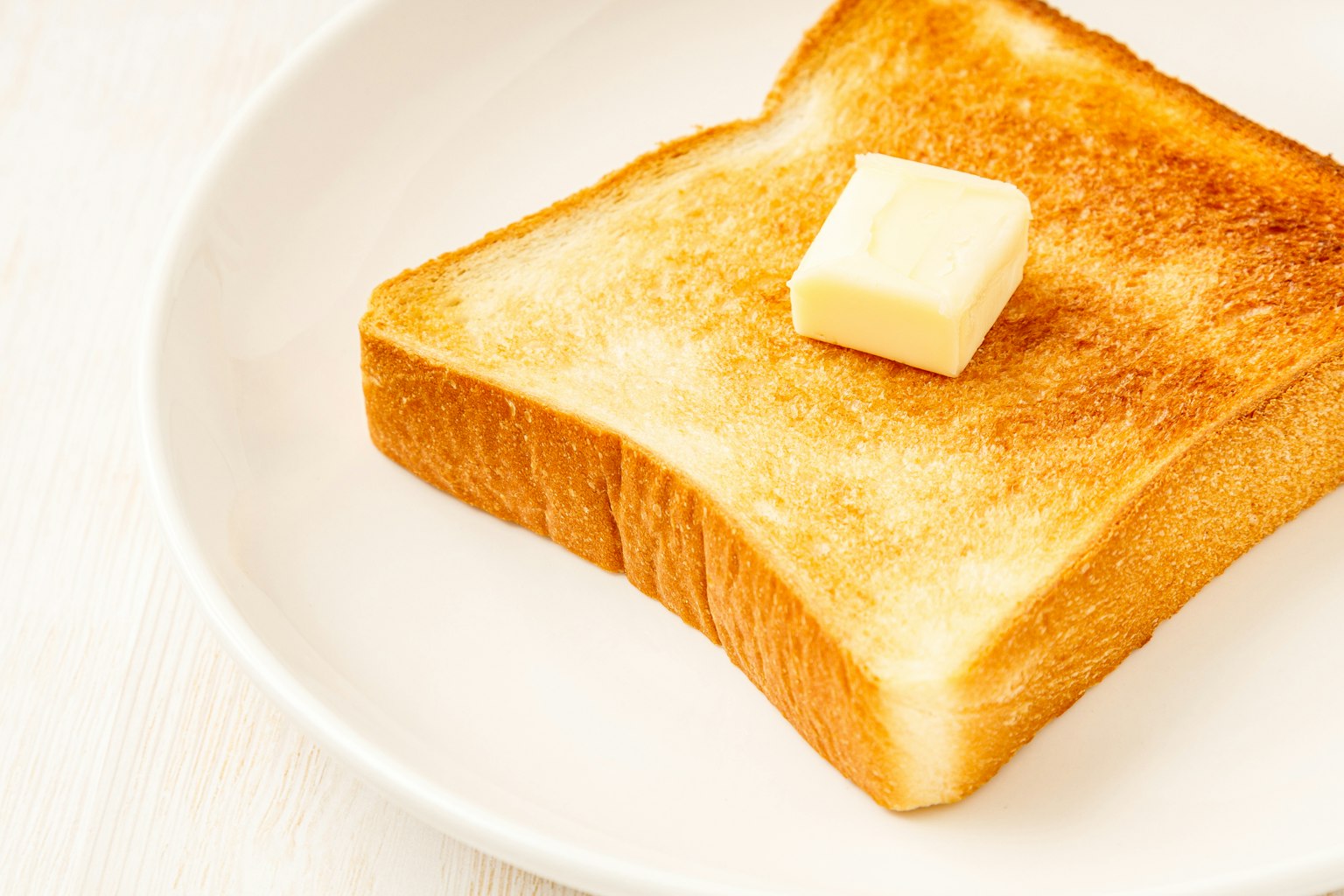 Một lát bánh mì nướng với một miếng bơ trên đỉnh