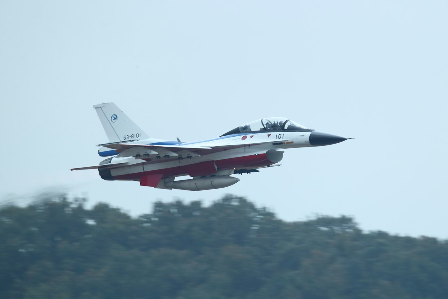 Un jet da combattimento bianco e rosso che vola nell'aria