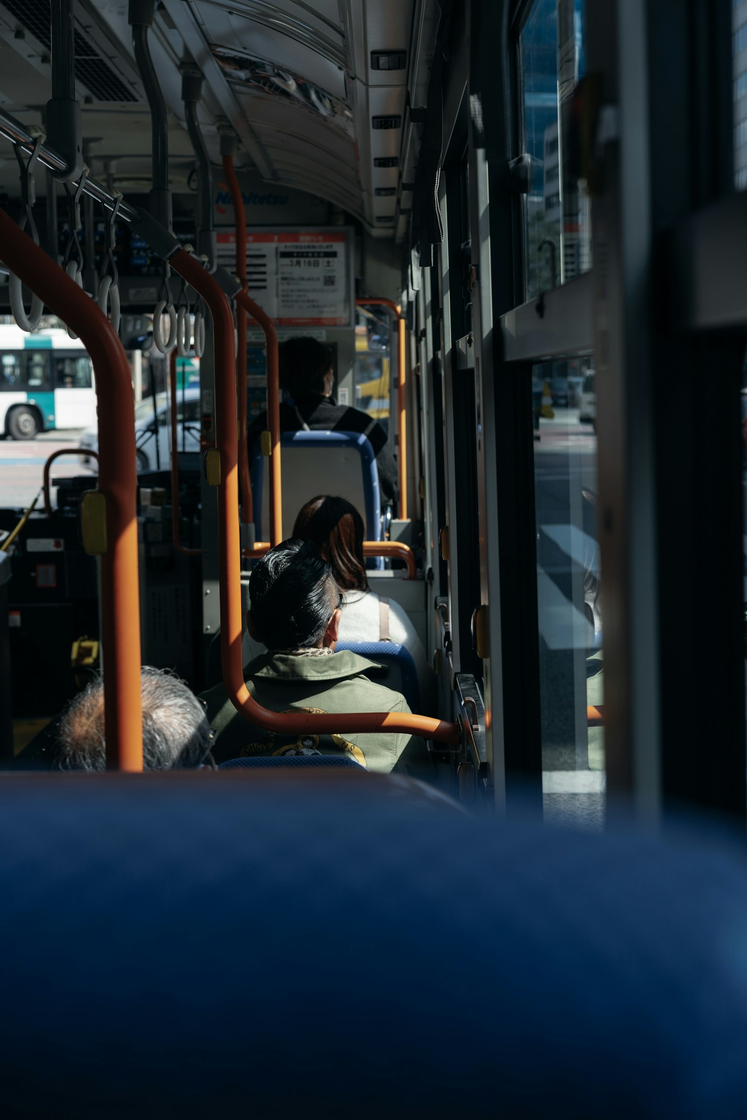 Vista interior de un autobús mostrando pasajeros sentados y el paisaje exterior por la ventana