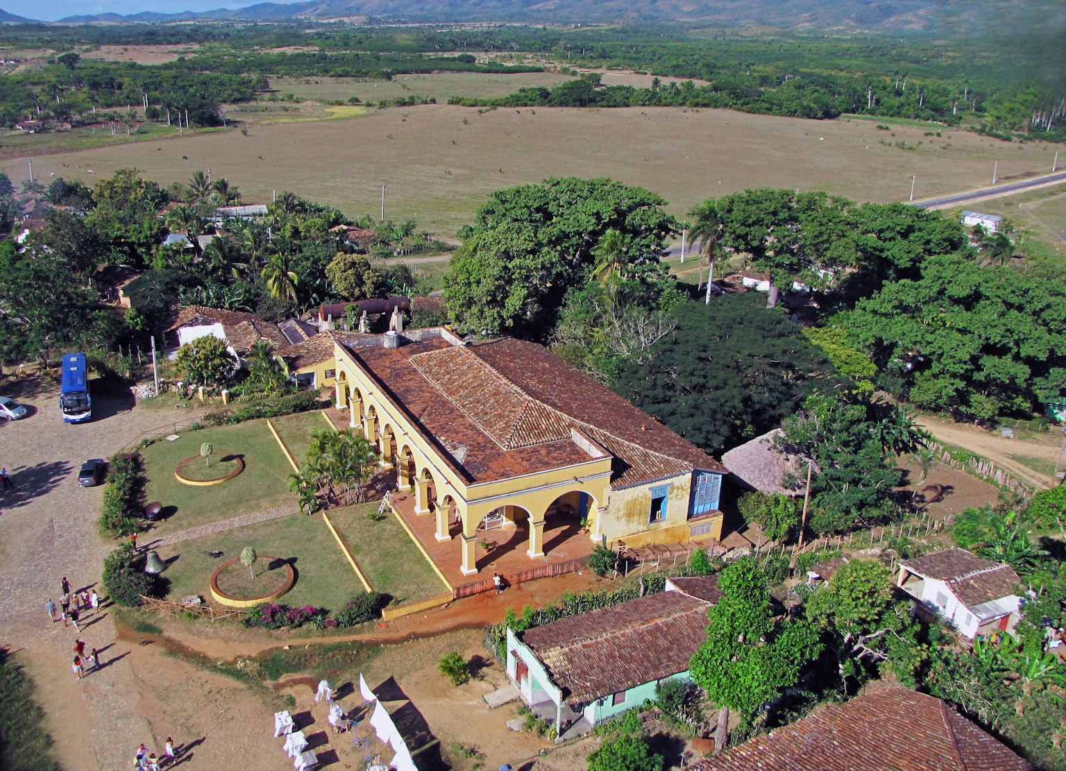 Vista aérea de un edificio histórico rodeado de vegetación exuberante y campos abiertos