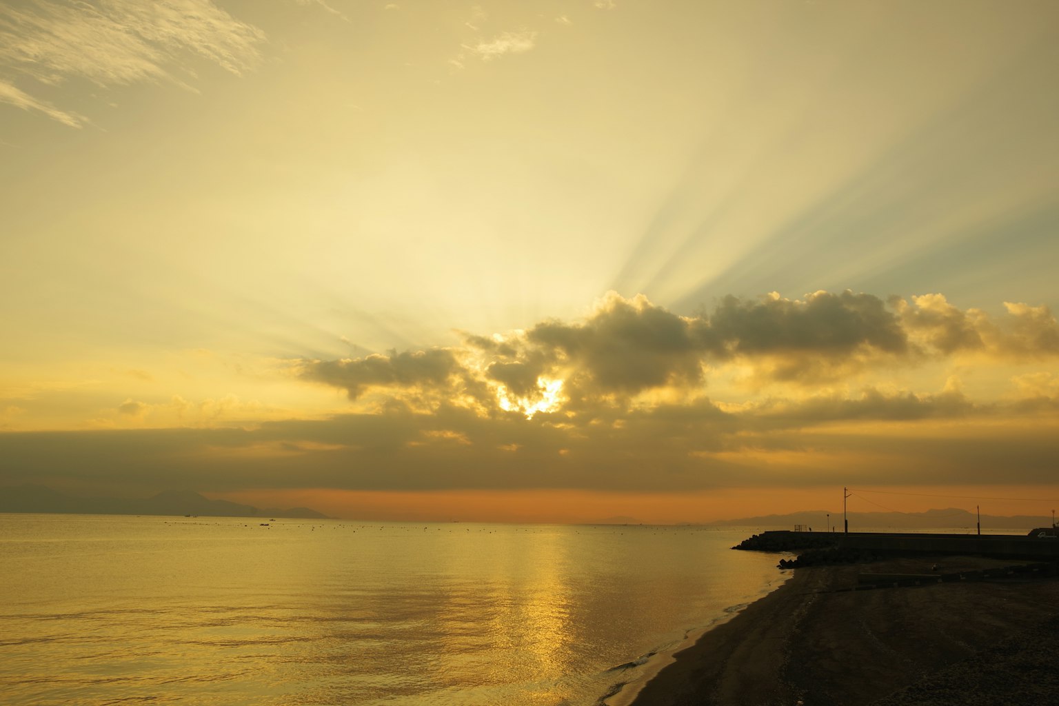Vista serena dell'oceano con un bellissimo tramonto e raggi di luce che si estendono nel cielo
