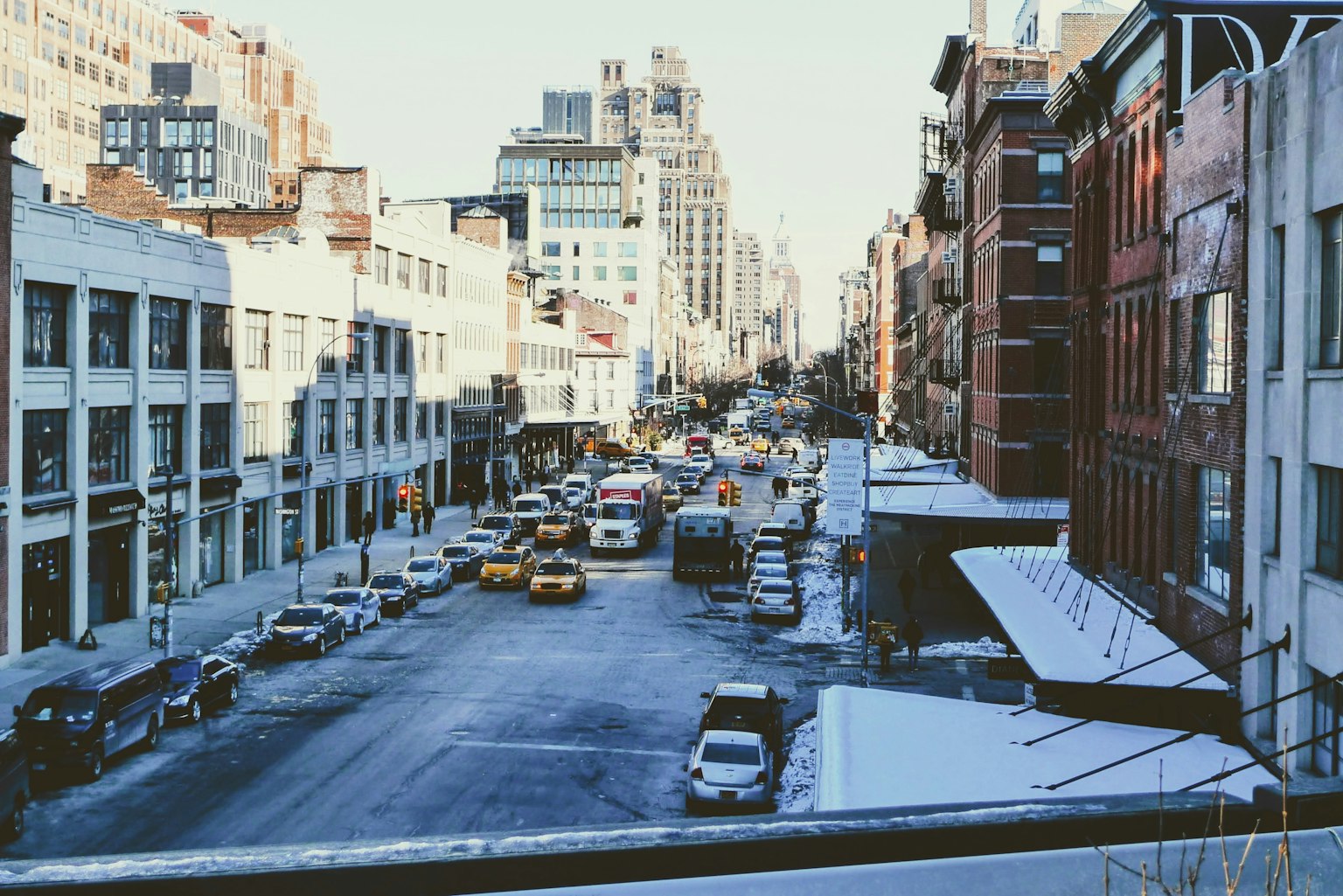 Escena de calle nevada con tráfico y edificios
