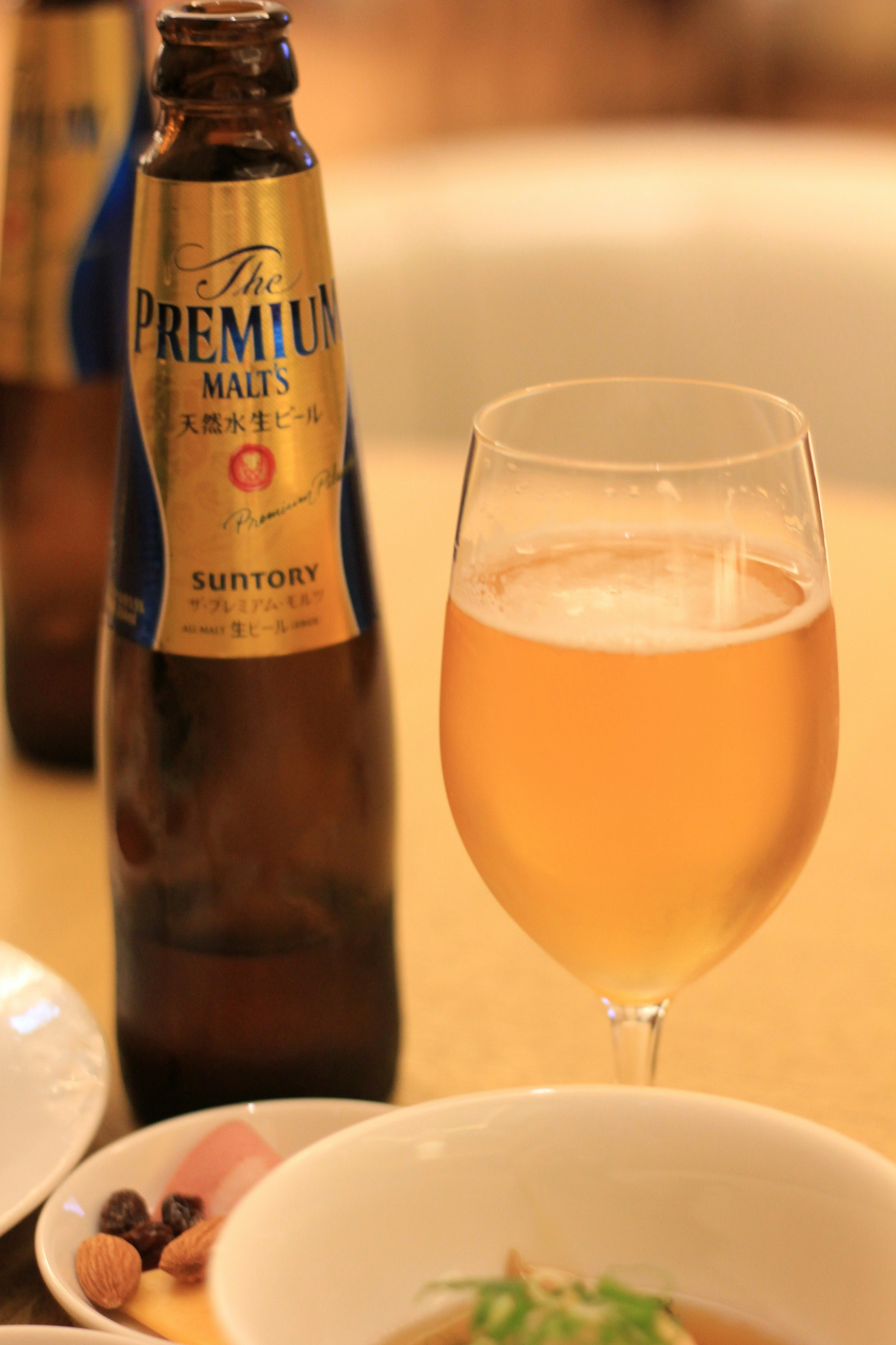 Bottiglia di birra e bicchiere con frutta secca su un tavolo