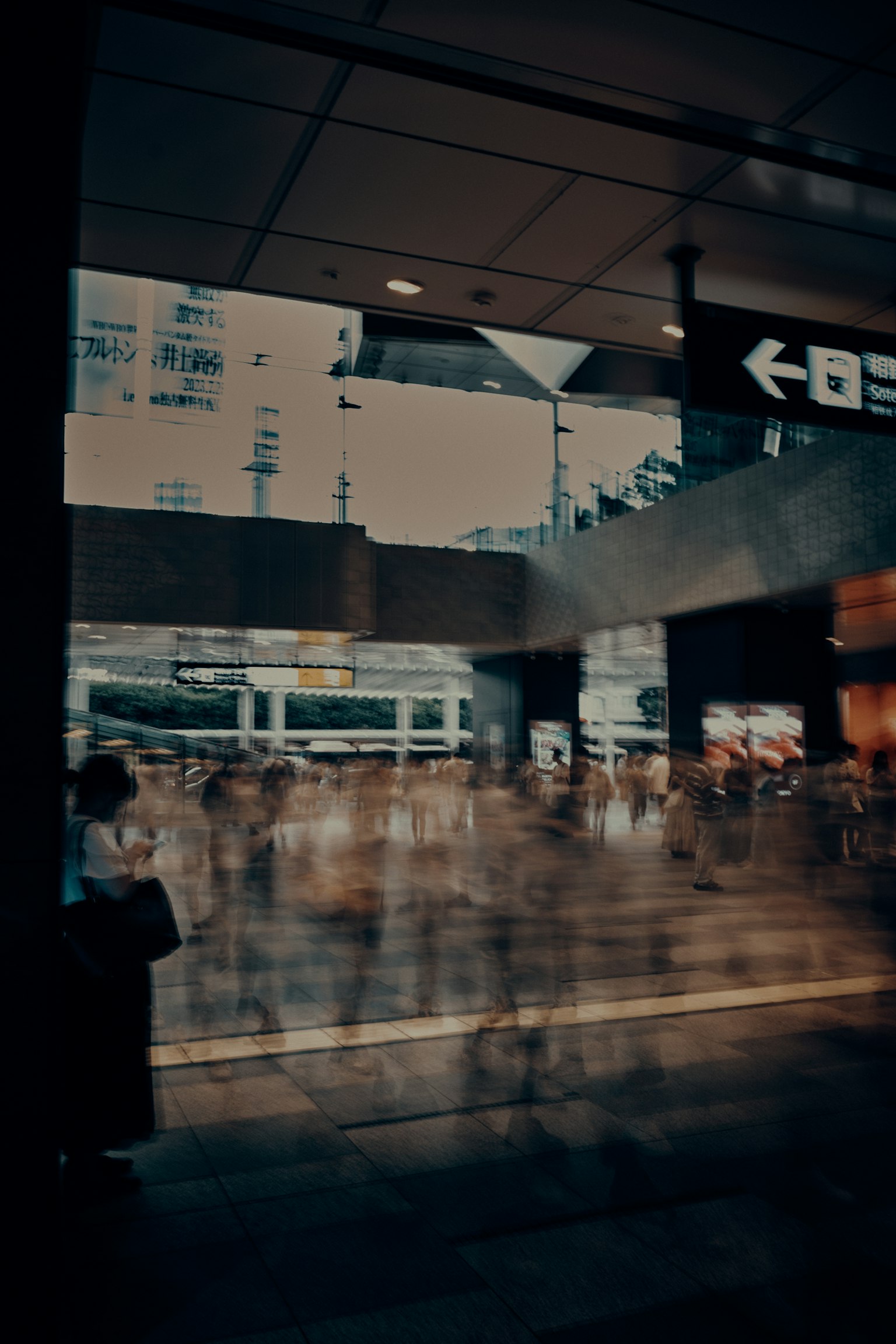 Blurred view of a busy station with flowing crowds and urban scenery