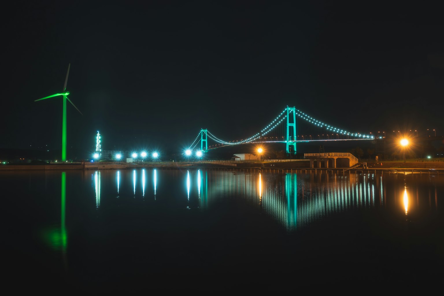 Malersiche Aussicht auf eine Brücke und Windturbine bei Nacht
