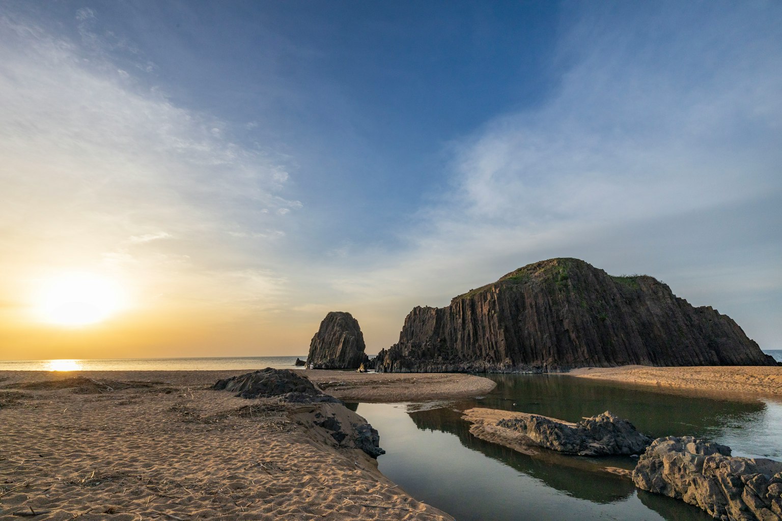 日落照亮的海岸风景与岩石形成