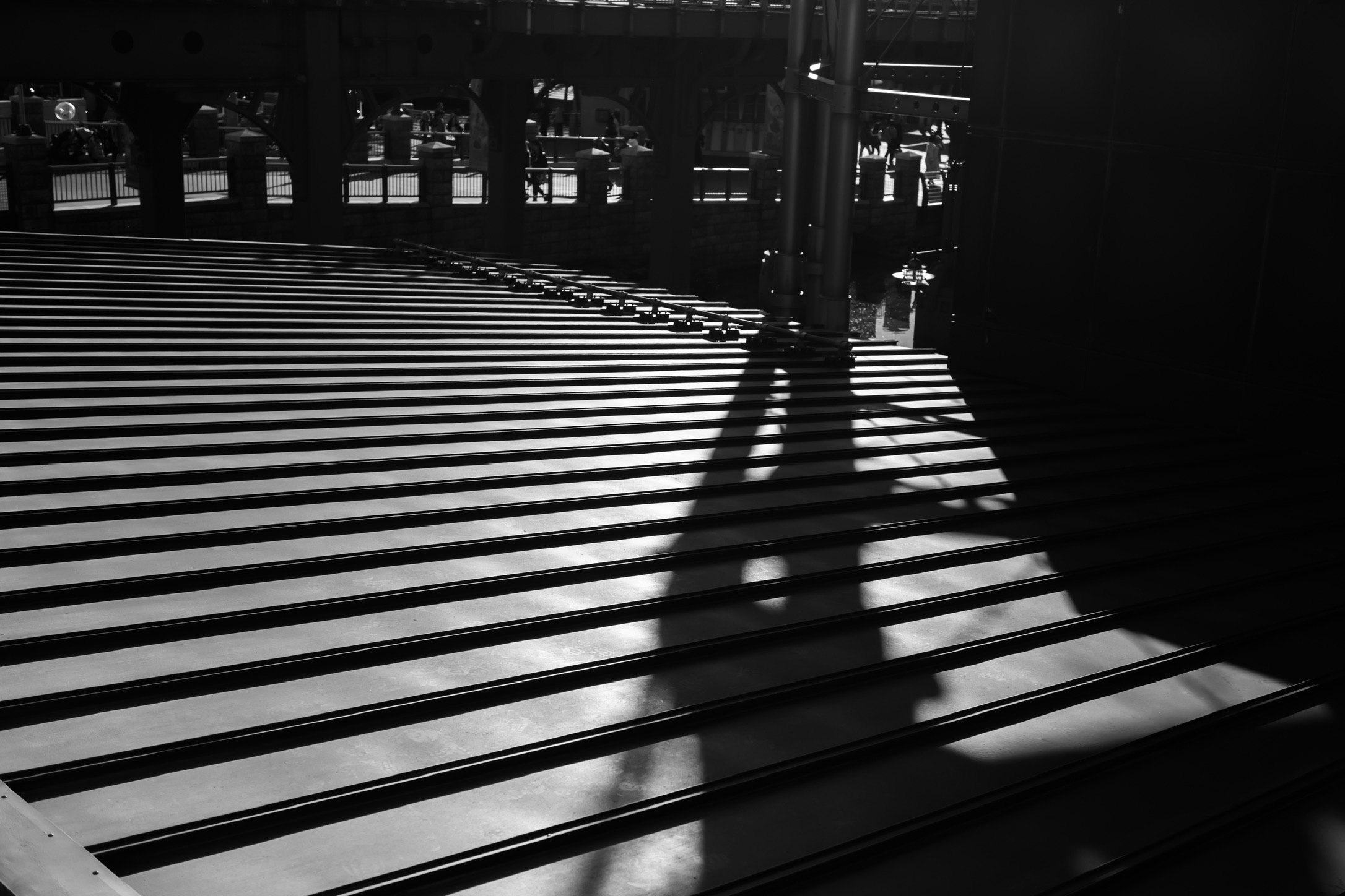 monochrome indoor corridor with railings and intersecting shadows