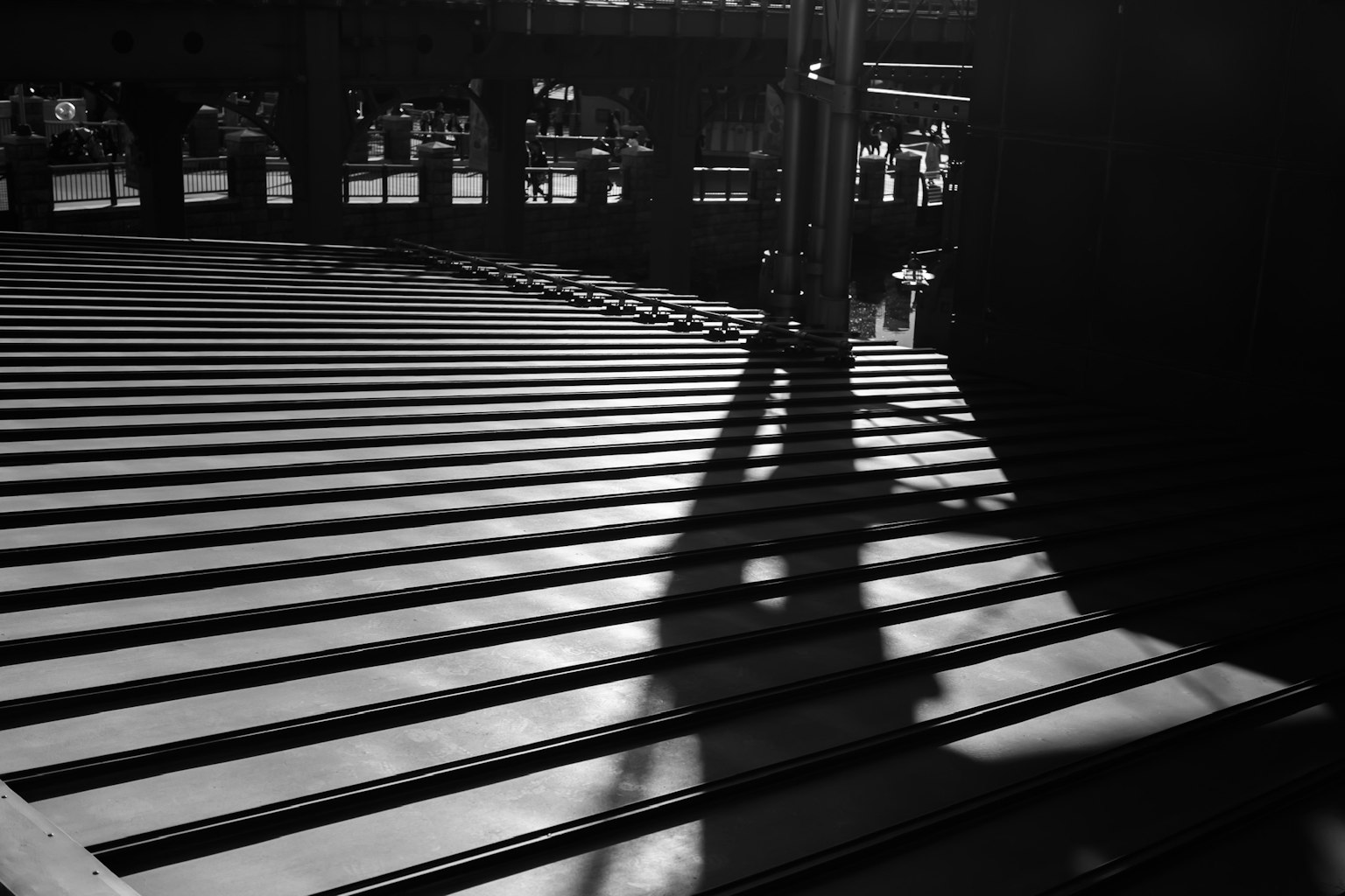 Image en noir et blanc présentant des ombres saisissantes sur un sol rayé